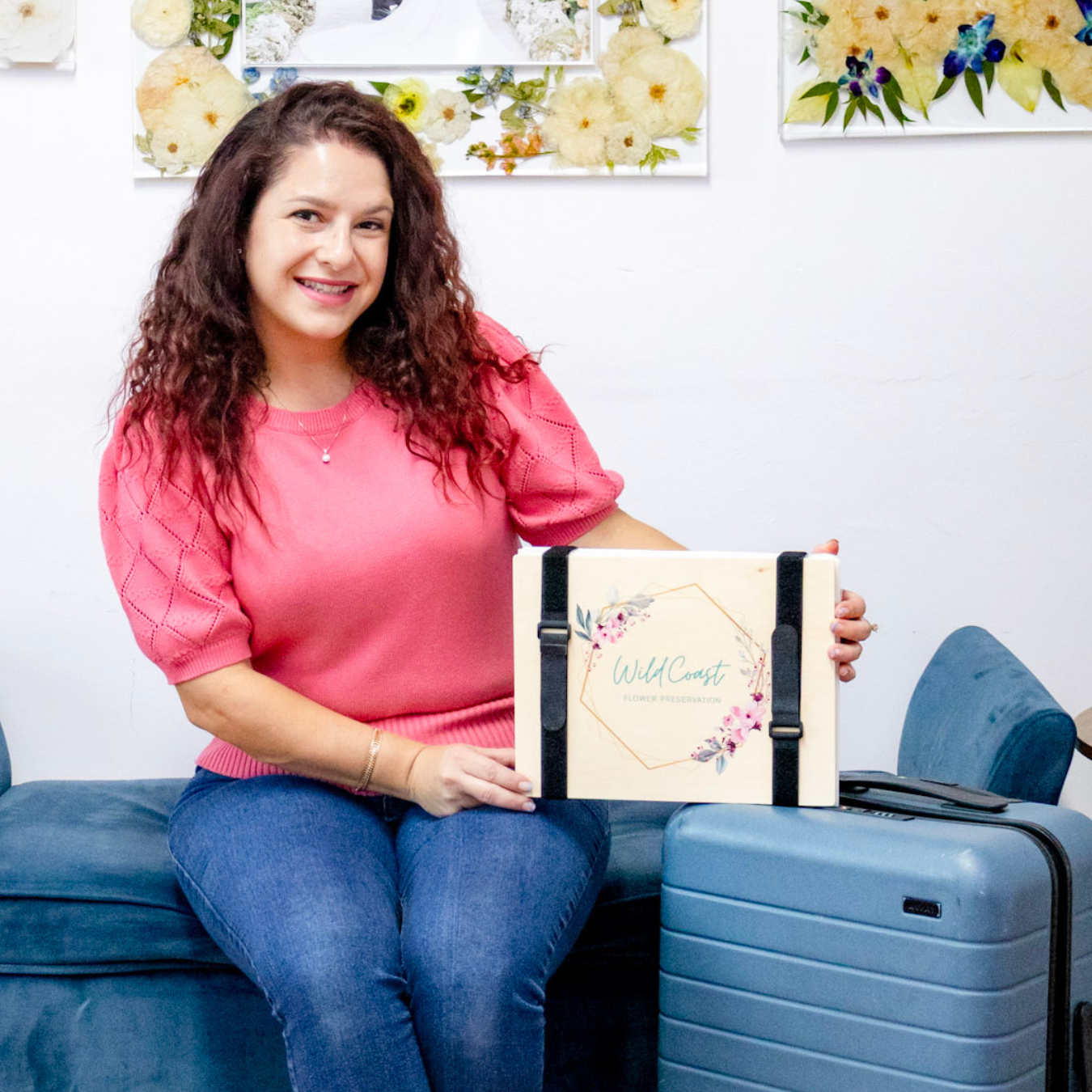 Woman holding a floral notebook with a blue suitcase next to her on a couch. how to preserve wedding flowers abroad
destination bride bouquet preservation