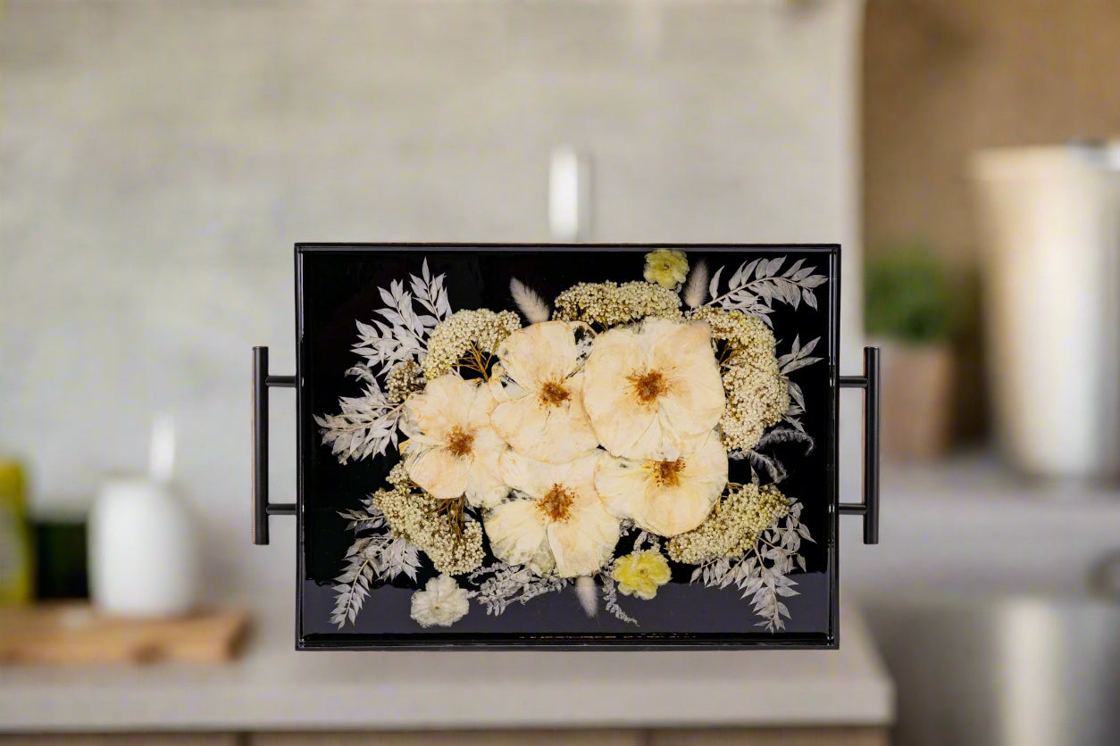 Elegant white wedding bouquet preserved in black acrylic resin tray featuring roses and baby's breath, showcasing wedding flower preservation artistry against sleek black background