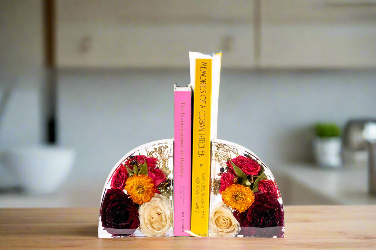 Bouquet Preservation resin book ends with orange and red bouquet flowers preserved inside holding two books on a kitchen counter decor