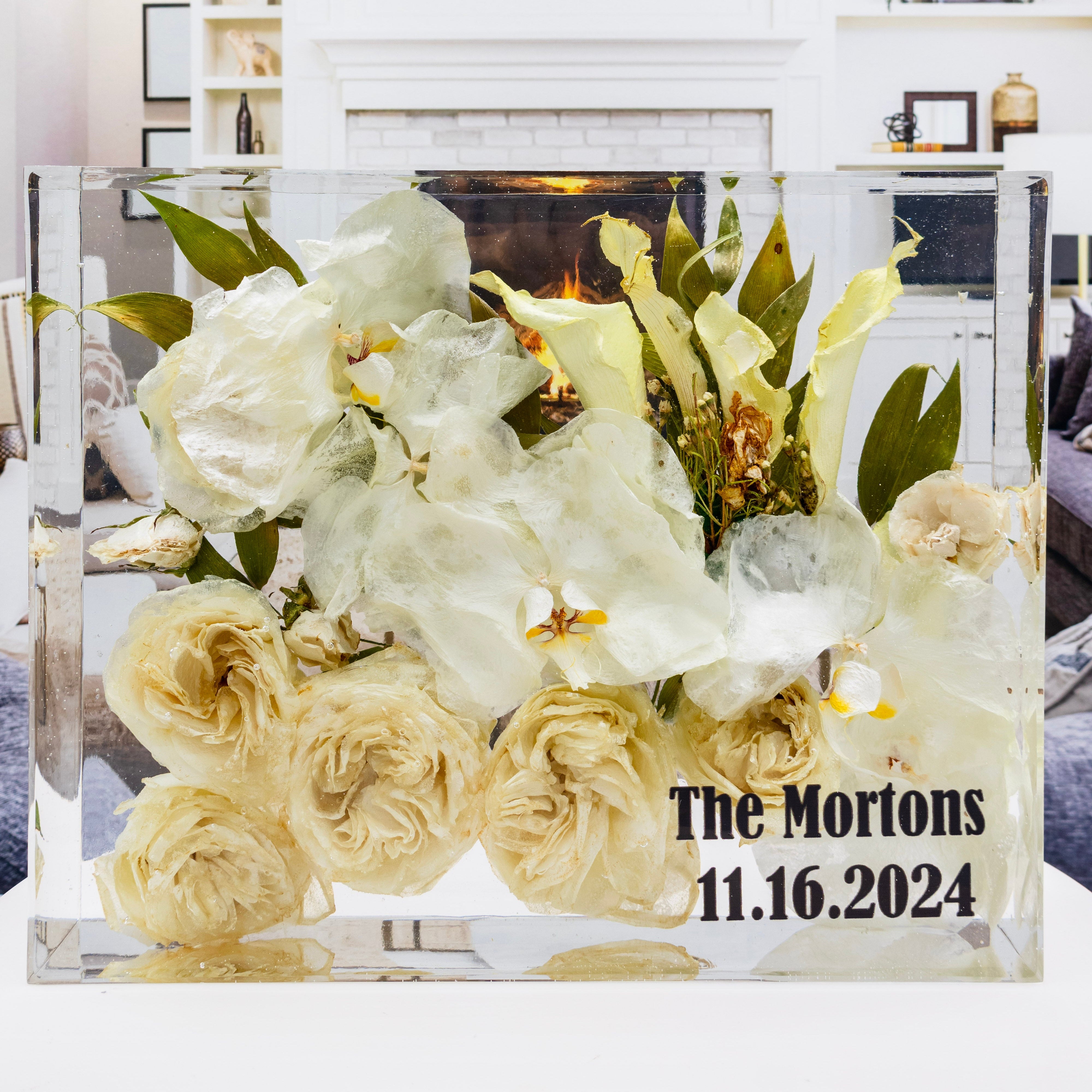 Clear acrylic block with white flowers and personalized text in a home setting