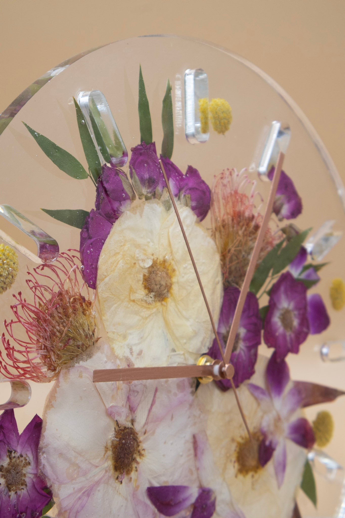 resin bouquet preservation wall clock with pressed flowers on a beige background