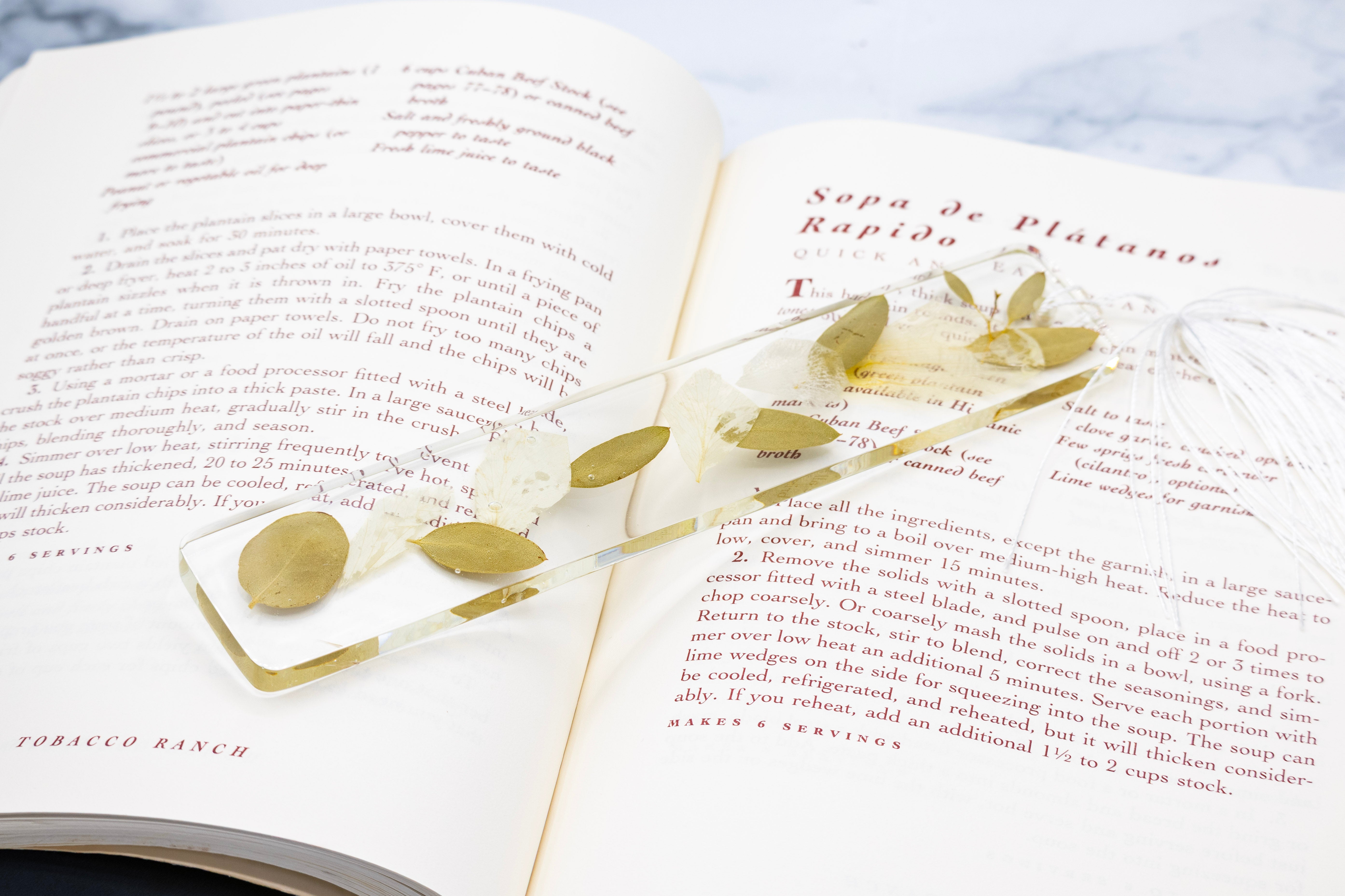 pressed flower bookmark on an open book with text