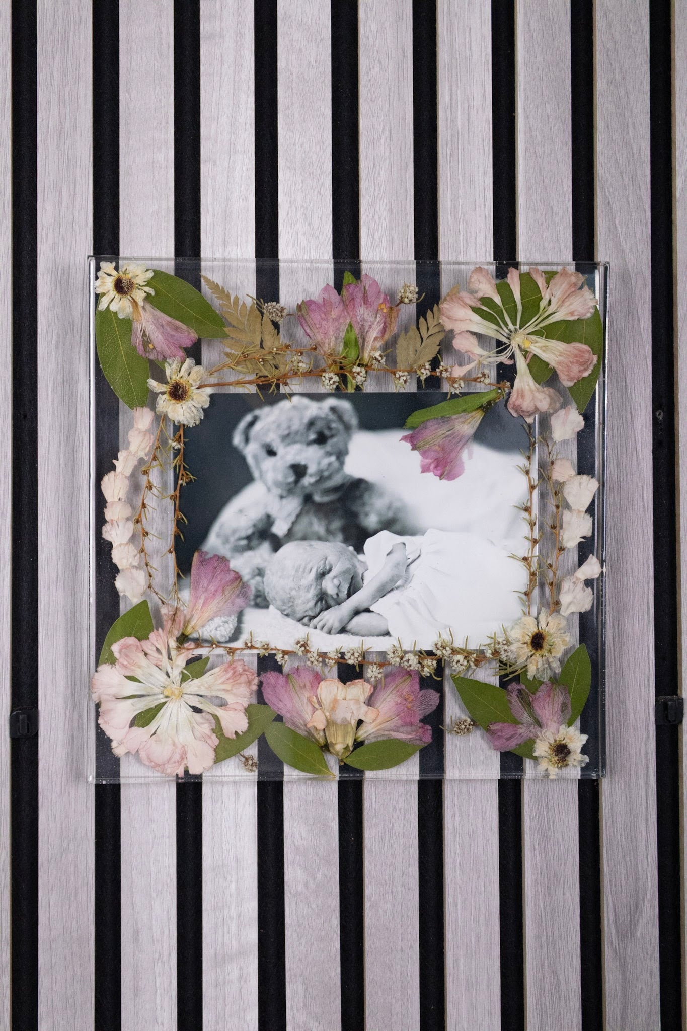 Decorative photo frame with floral elements on a striped background