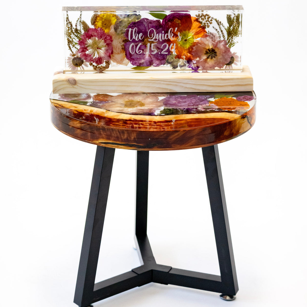Tall portrait photo of a pressed flower large ring holder with layered dried petals on a wood surface