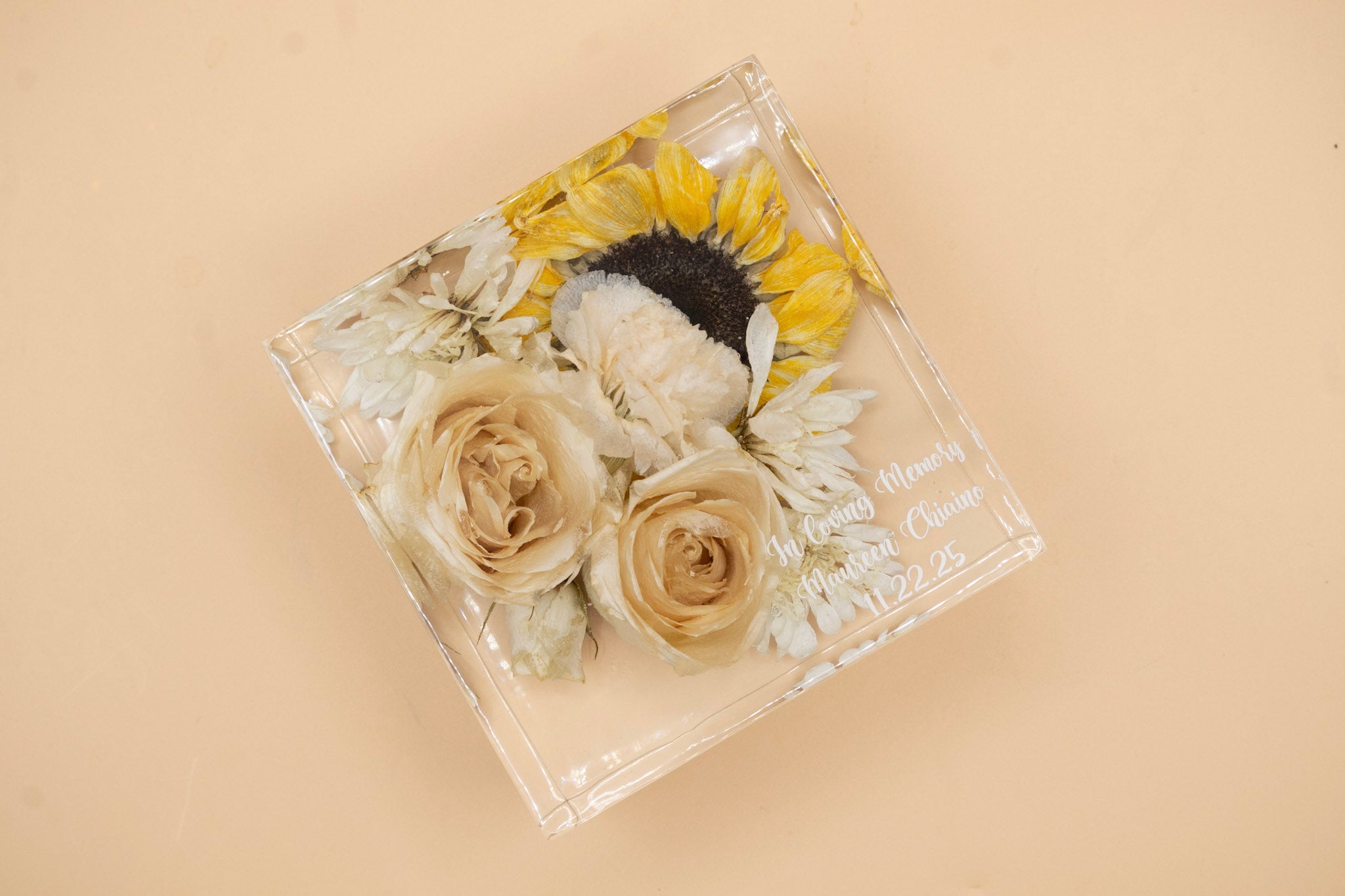 square preserved flower resin block featuring sunflowers and white roses with memorial inscription in the corner on a beige background