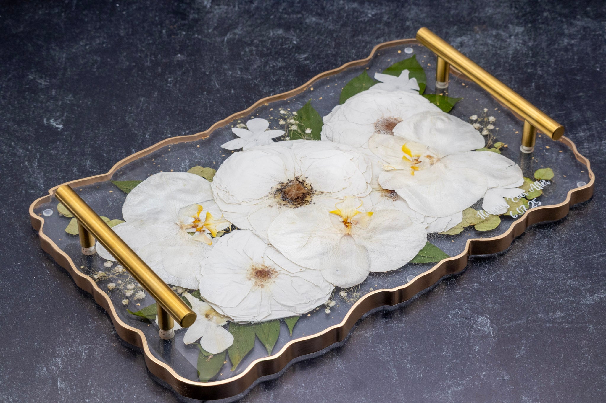 Pressed Orchid Decorative tray with white flowers and gold handles on a dark background