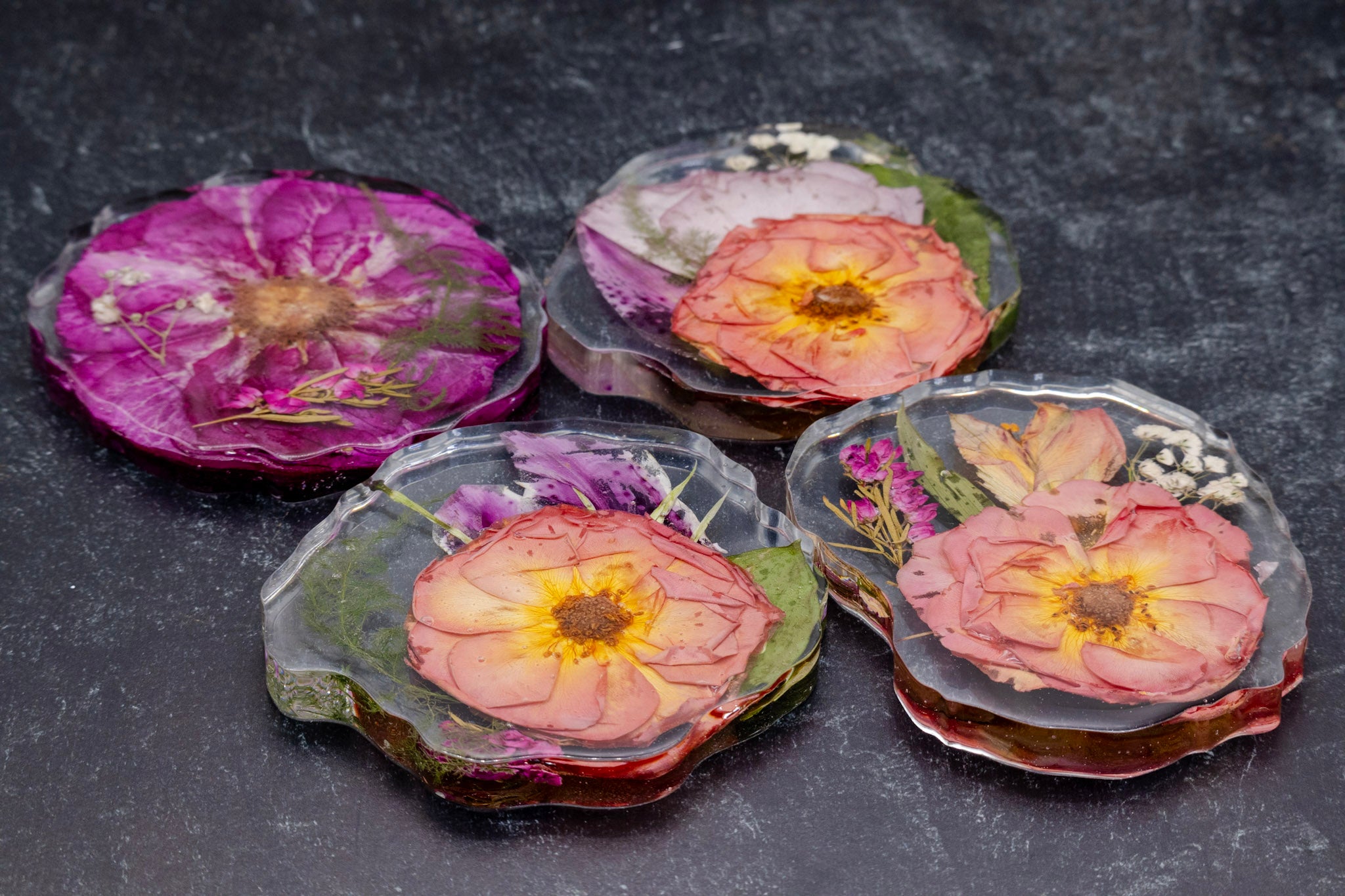 Set of floral coasters on a dark surface