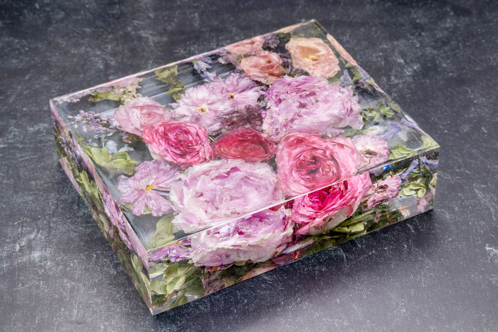 Decorative box with floral design on a dark surface