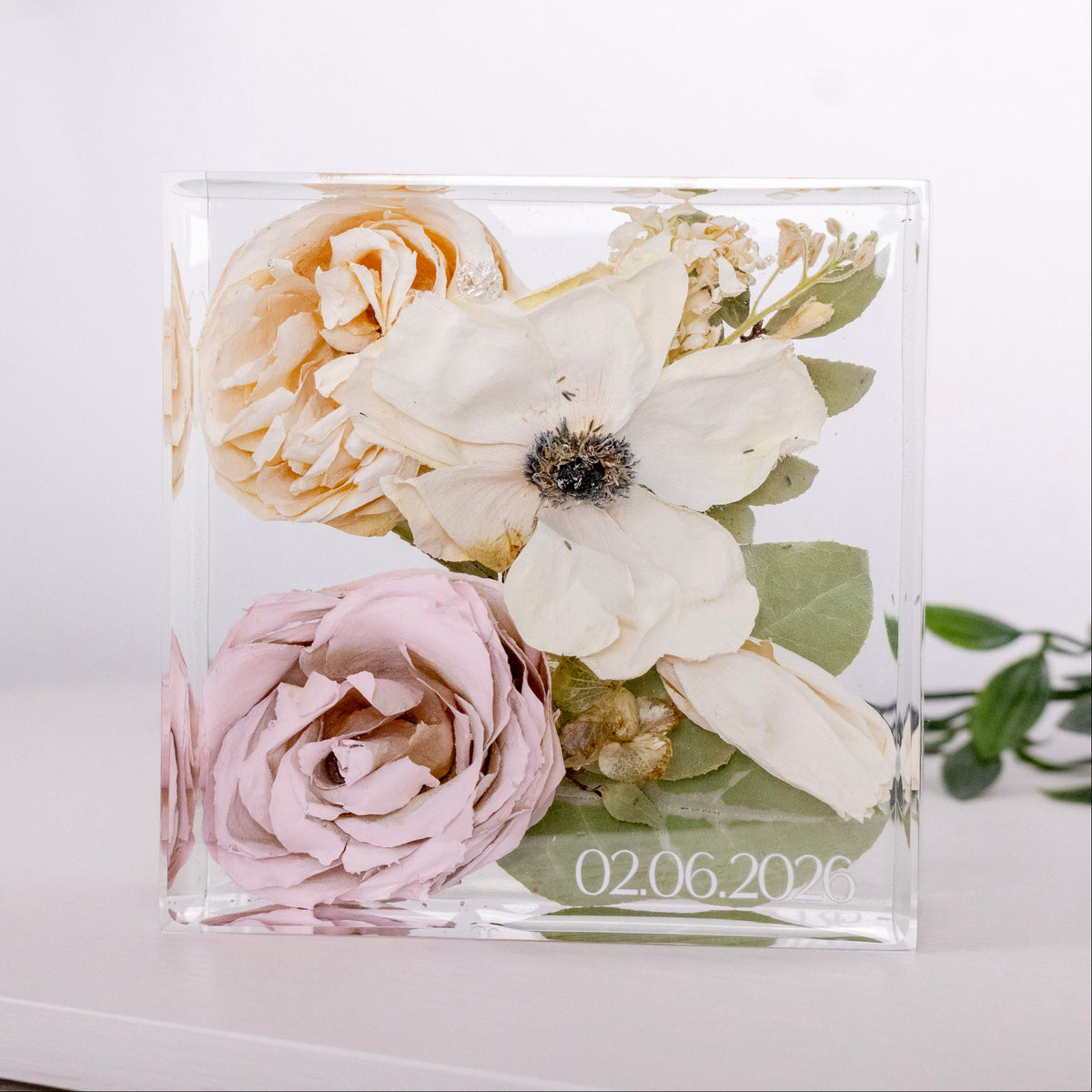 resin cube with preserved anemone, pink rose and greenery with date in white text on the bottom corner