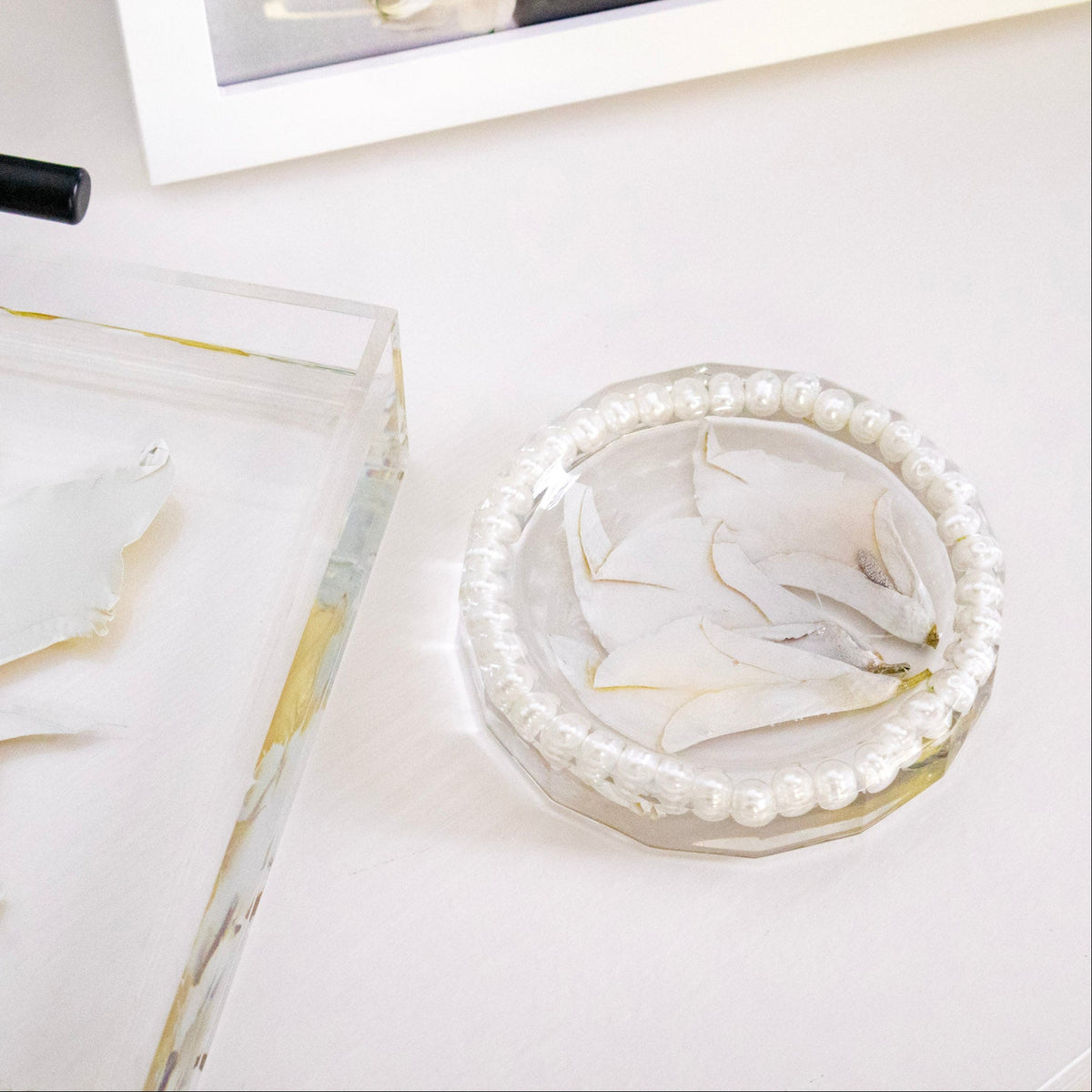 pressed calla lily preserved in resin ring dish with white pearls and color correction