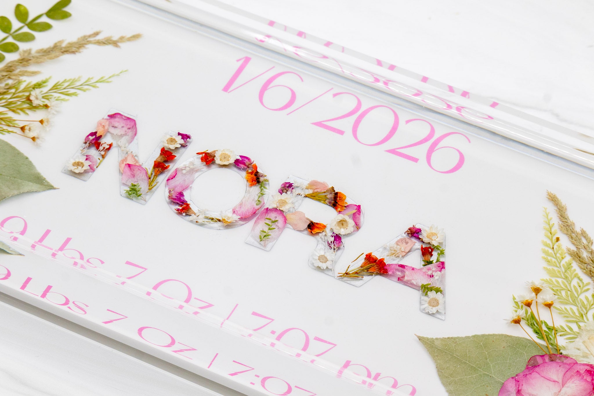 Resin rectangle block with floral lettering and baby pink text on a white background