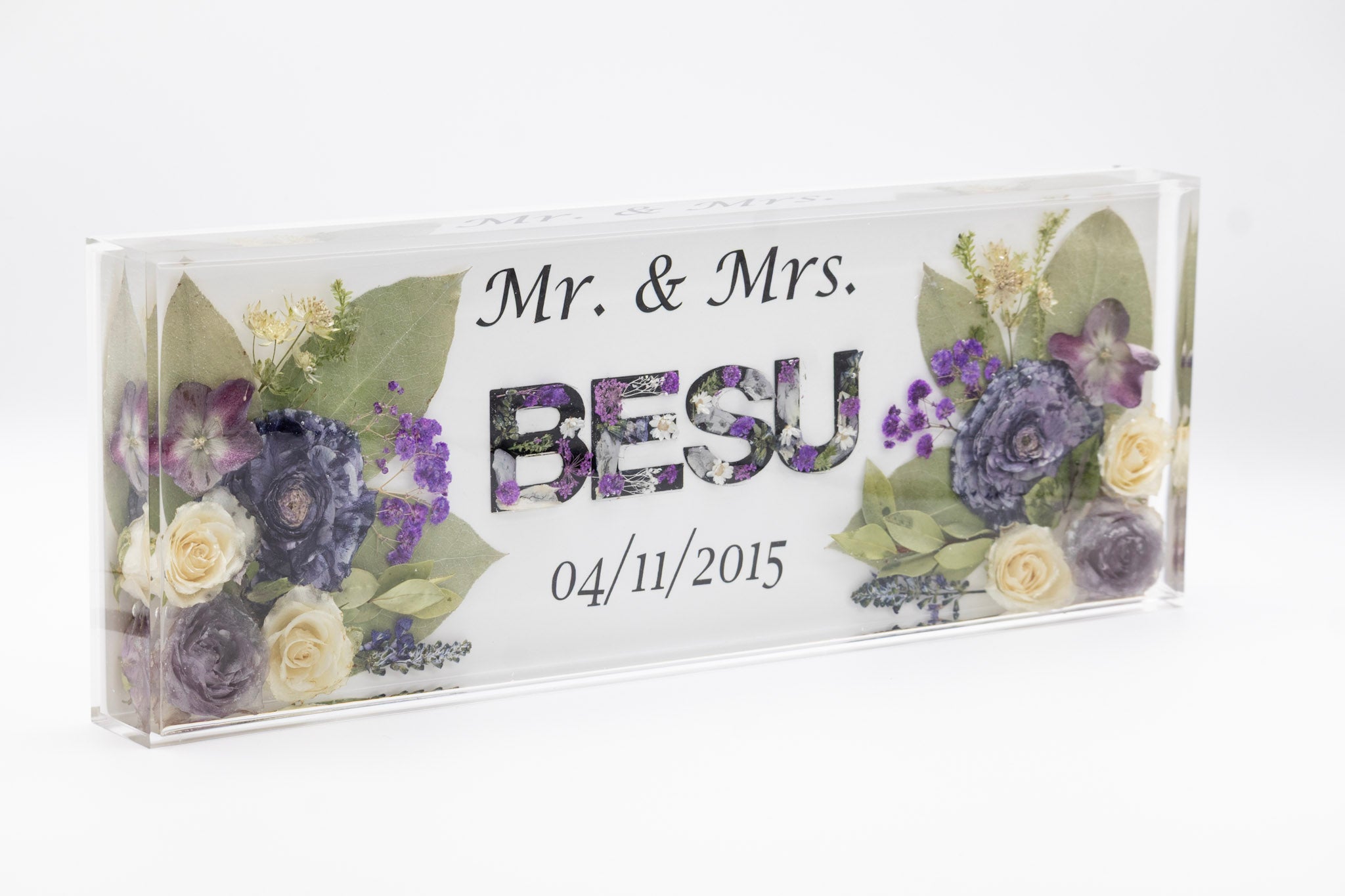 Decorative acrylic sign with resin flower preservation and 'Mr. & Mrs. Besu' text on a white background