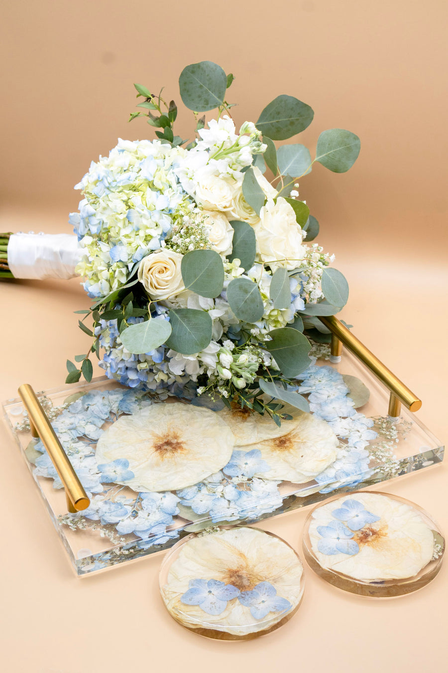 Fresh wedding bouquet next to a pressed flower resin tray and coasters made from the same bouquet flowers