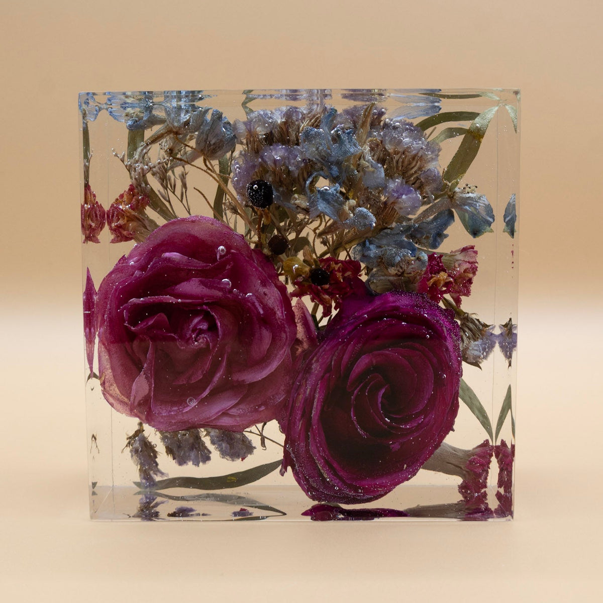 Resin Flower Preservation in 5x5 epoxy block featuring two pink roses and blue flowers on a beige background