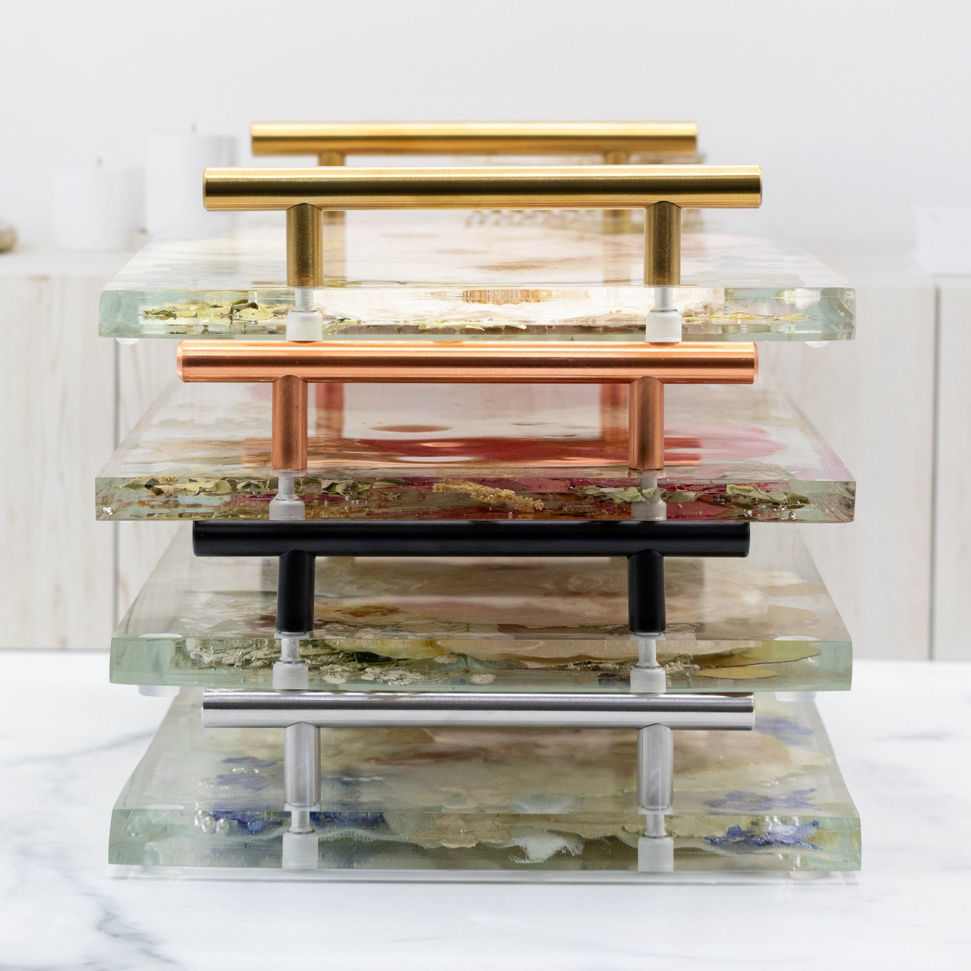 Stack of trays with handles in various finishes on a white background with text about hardware finishes.