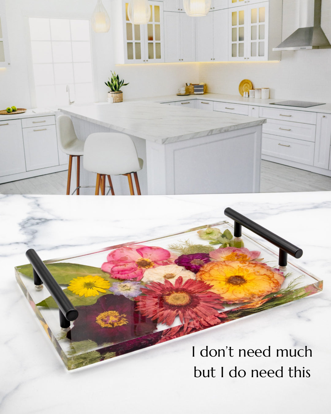 Decorative glass tray with floral design and black handles on a kitchen counter.