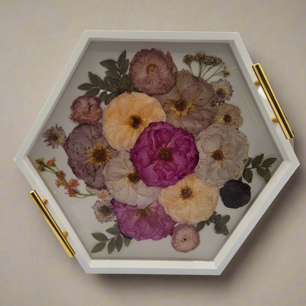 pressed flower preservation of wedding bouquet inside a white wood hexagon ottoman tray with gold handles on a beige background