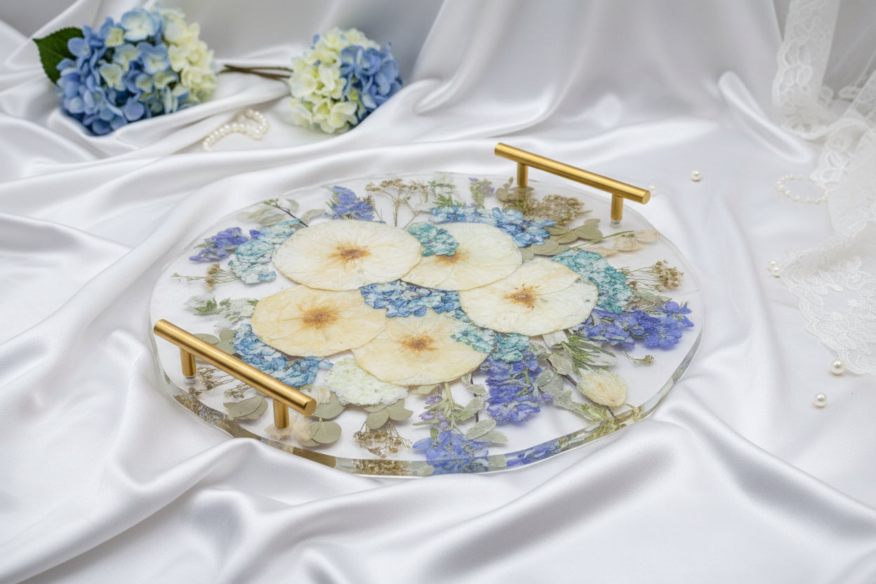 round resin tray with pressed flowers and a gold handle and circle coasters on a beige background