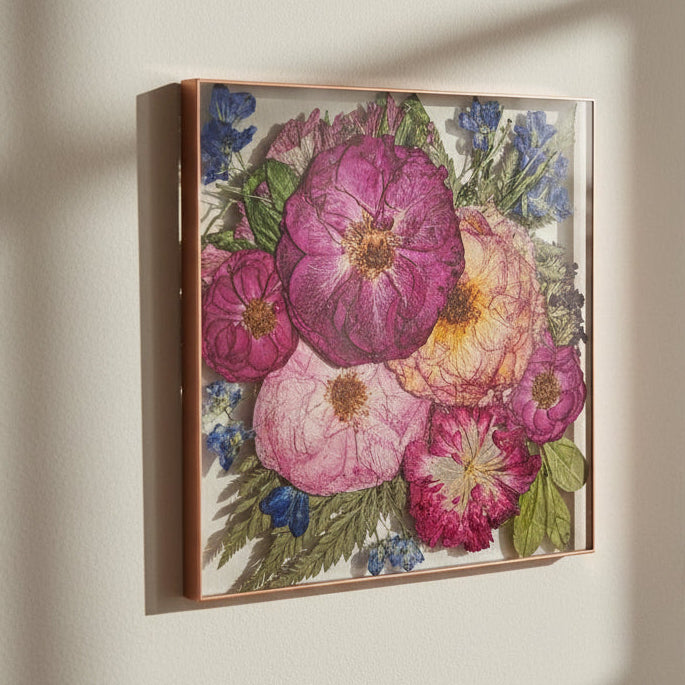 Pressed flower floating frame with rose gold painted edge hanging on living room wall