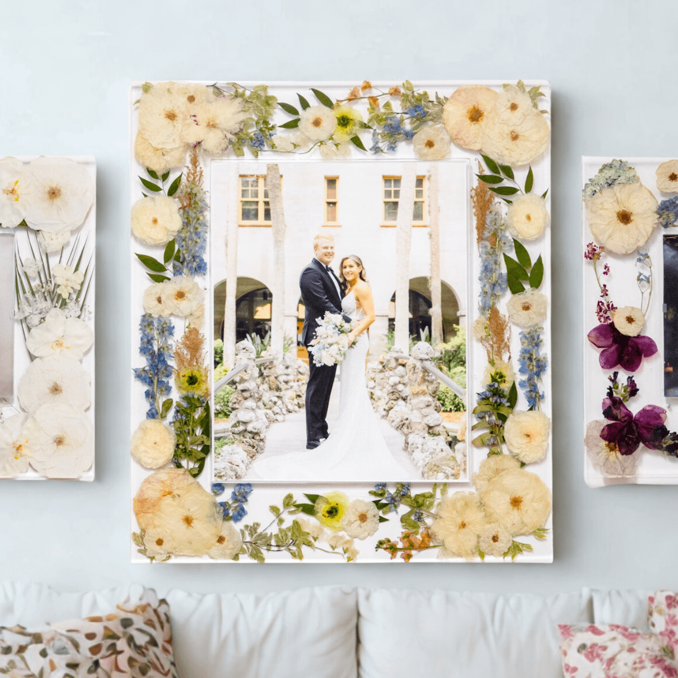 Floral photo frame with a couple's wedding photo on a light blue wall.