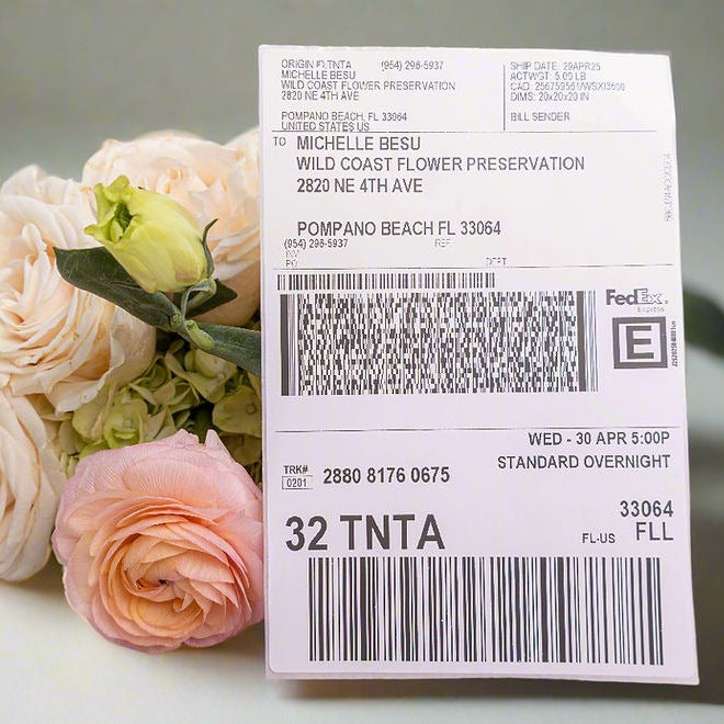 FedEx Priority Overnight shipping label in front of a pink rose arrangement for flower preservation shipping