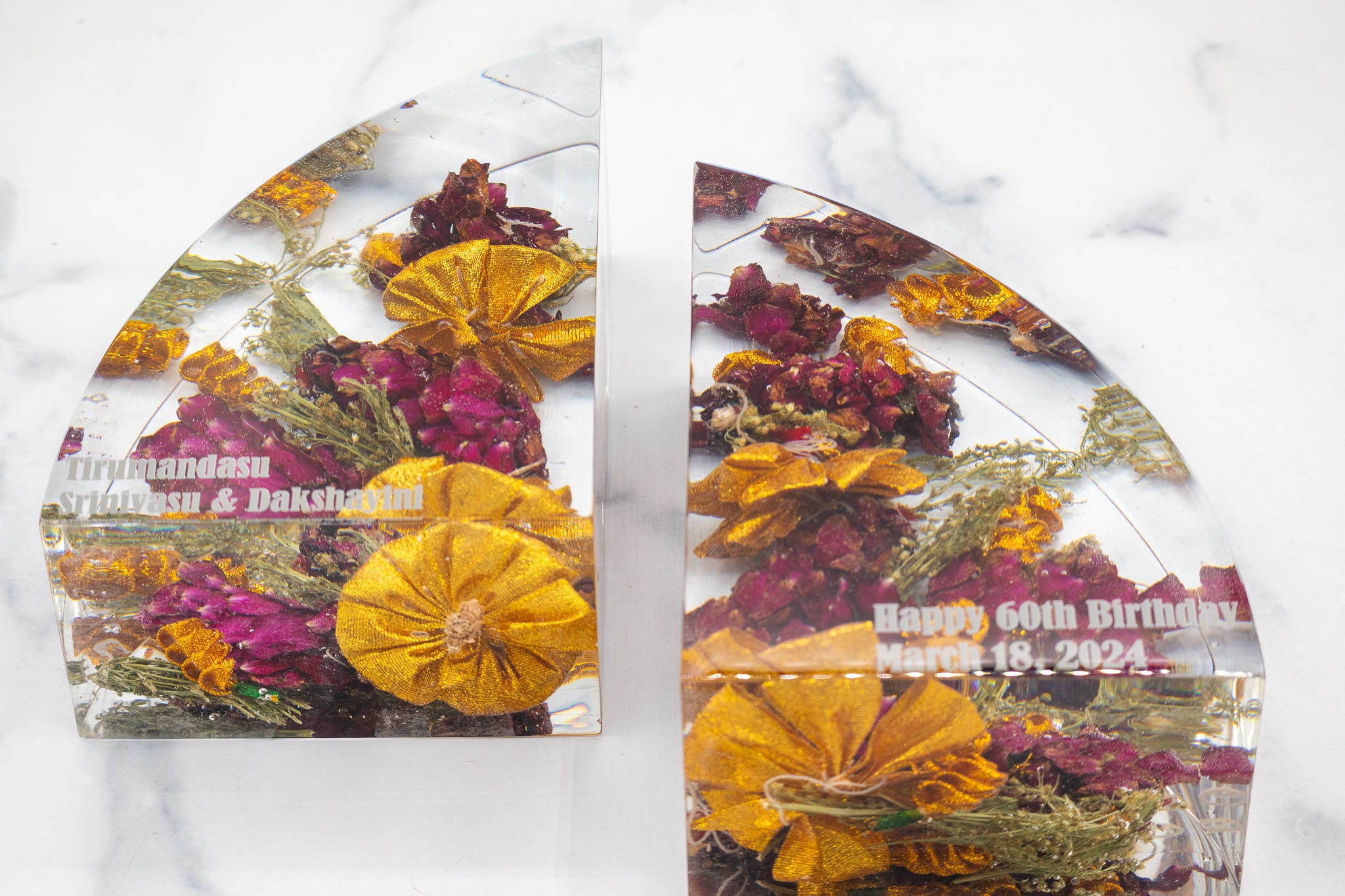 Two preserved wedding garland bookends floral in epoxy resin and text on a white marble background