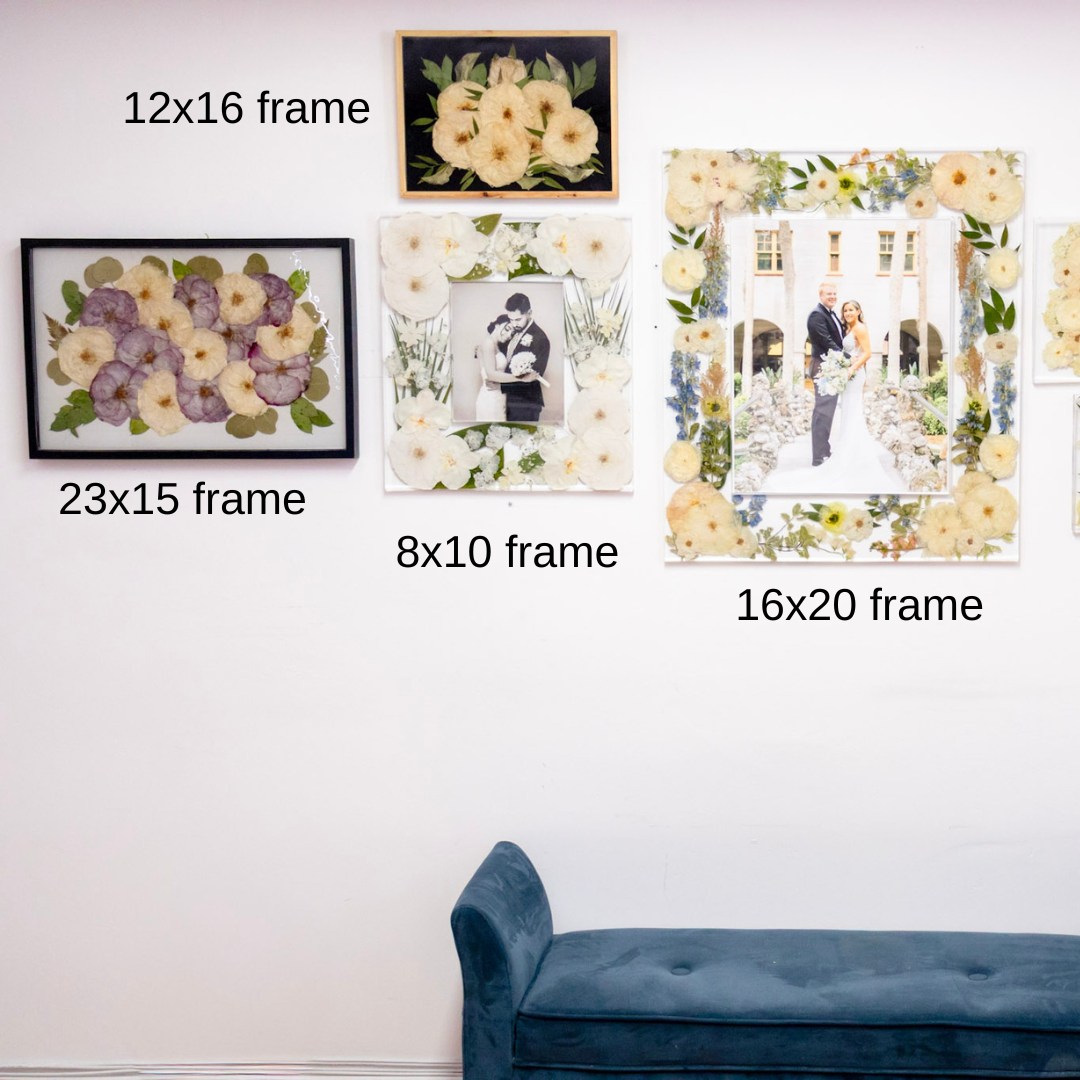 Wall with various pressed flower photo frames of different sizes and styles, including floral and couple photos. All frames made with epoxy resin.