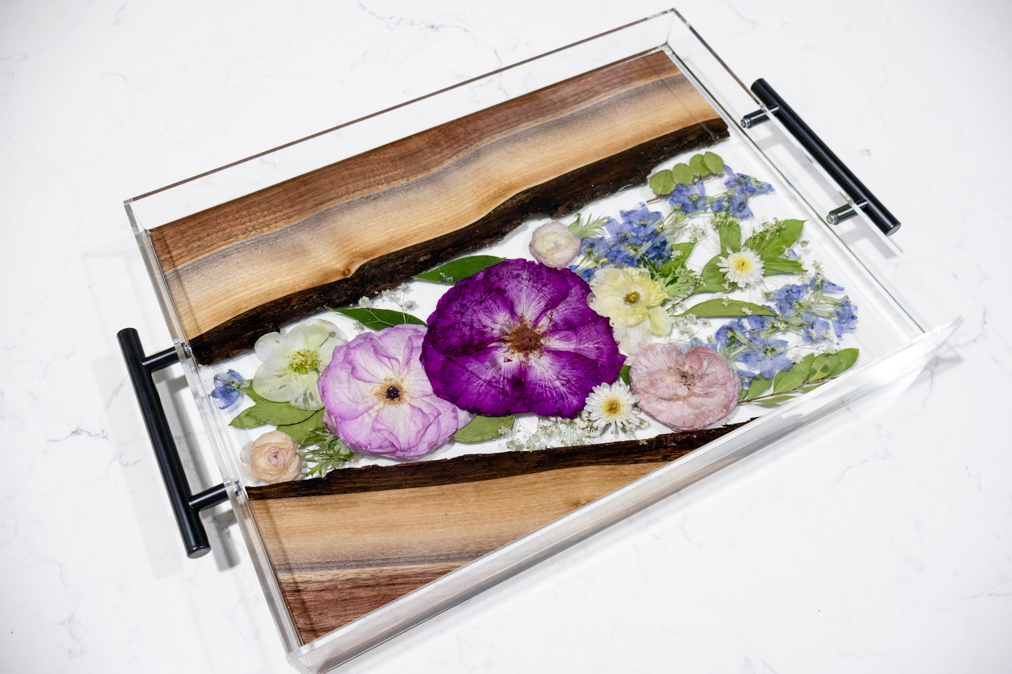 Decorative tray with pressed flowers and wooden accents.