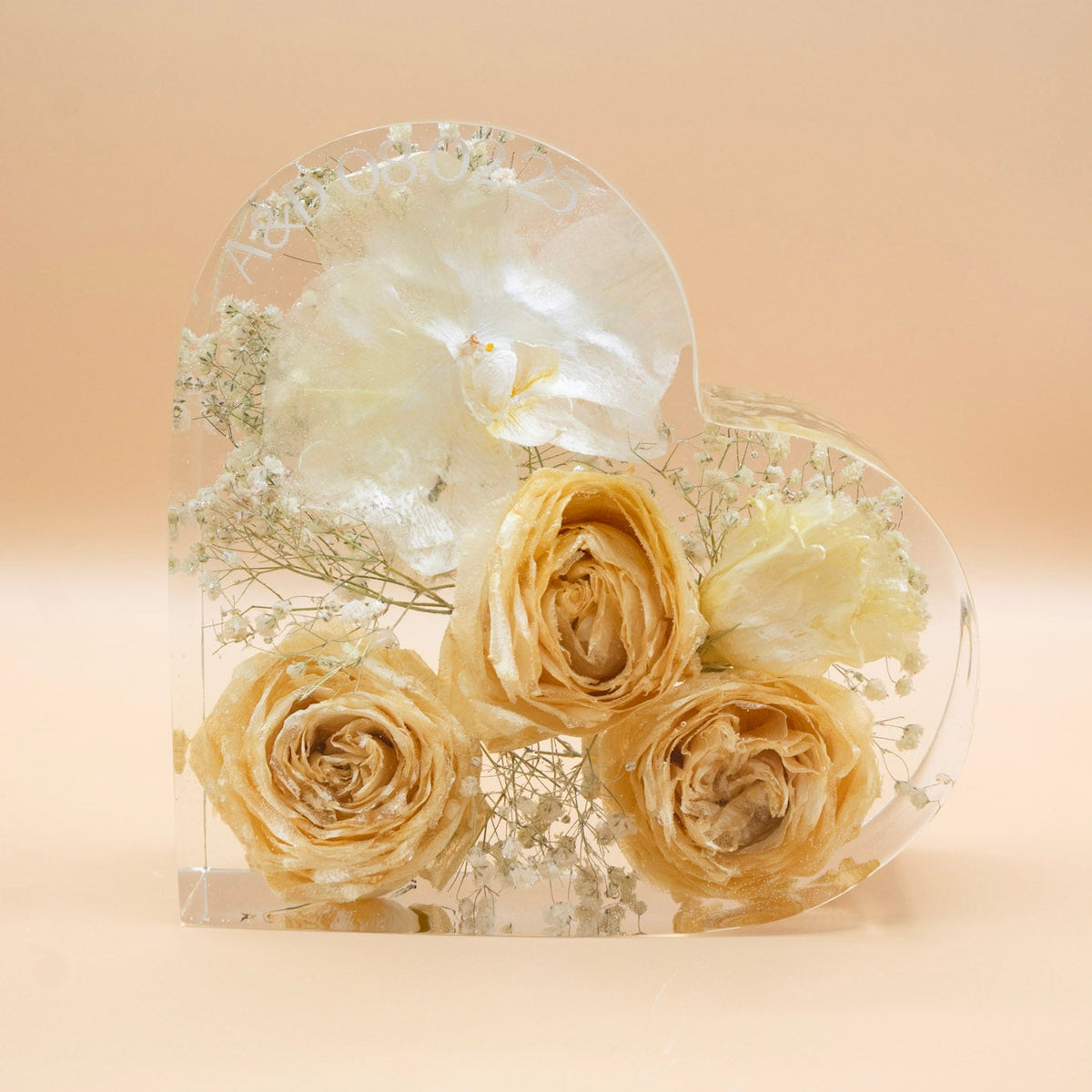 Resin Heart shape Preservation of white Orchid and White Rose with baby's breath dried and encased in epoxy with date personalization on a beige background
