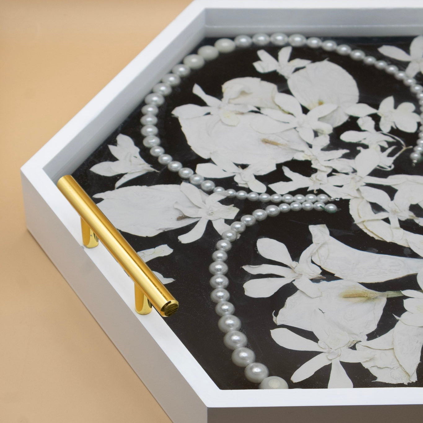 Hexagon ottoman tray with white pressed flowers and pearls set in black resin, gold handle and white frame keepsake.