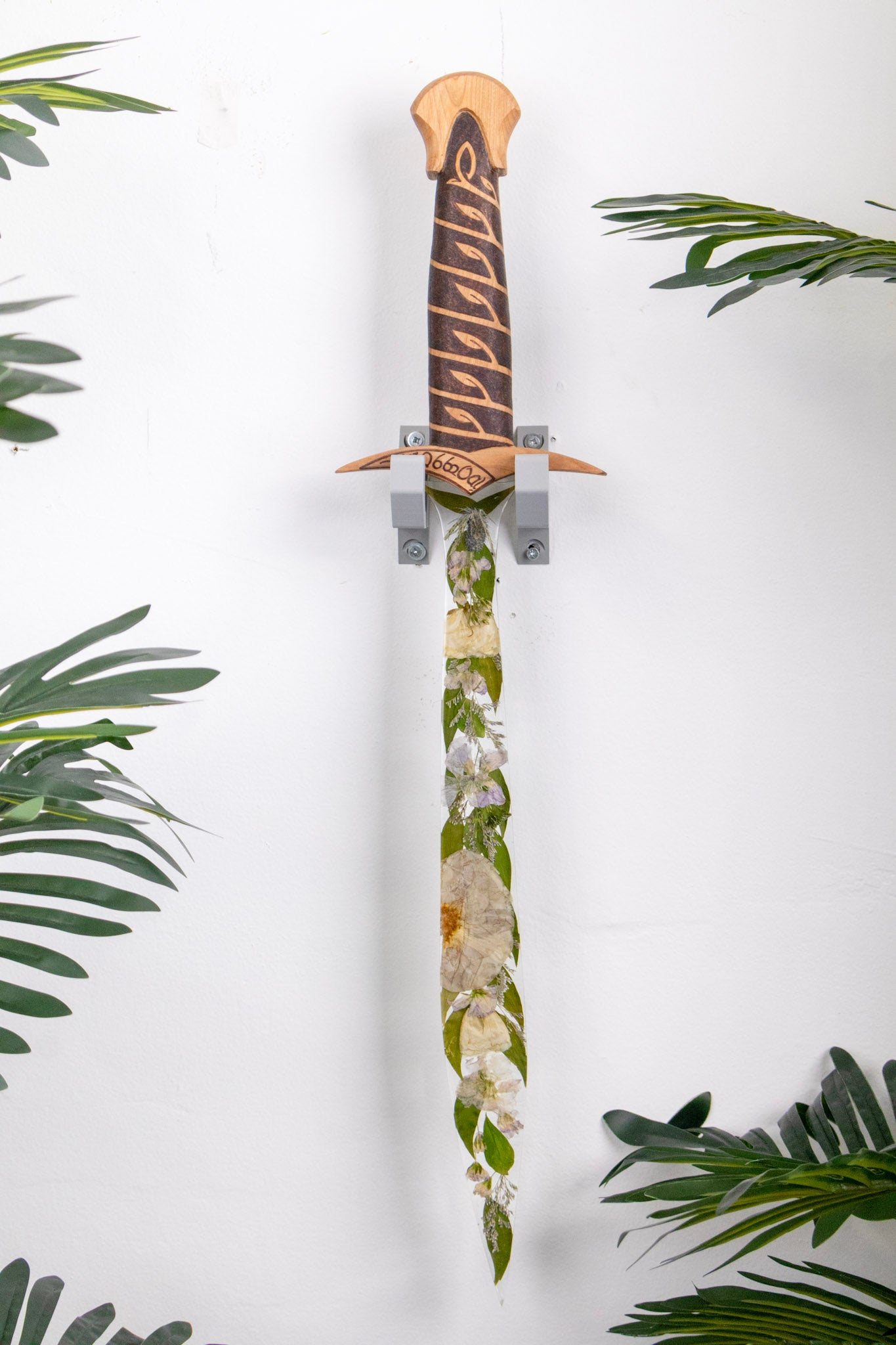 resin sword with preserved wedding bouquet in the blade with wood handle hanging on the wall