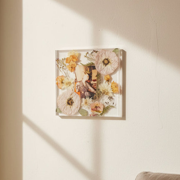 Pressed flower preservation frame with photo keepsake hanging on living room wall