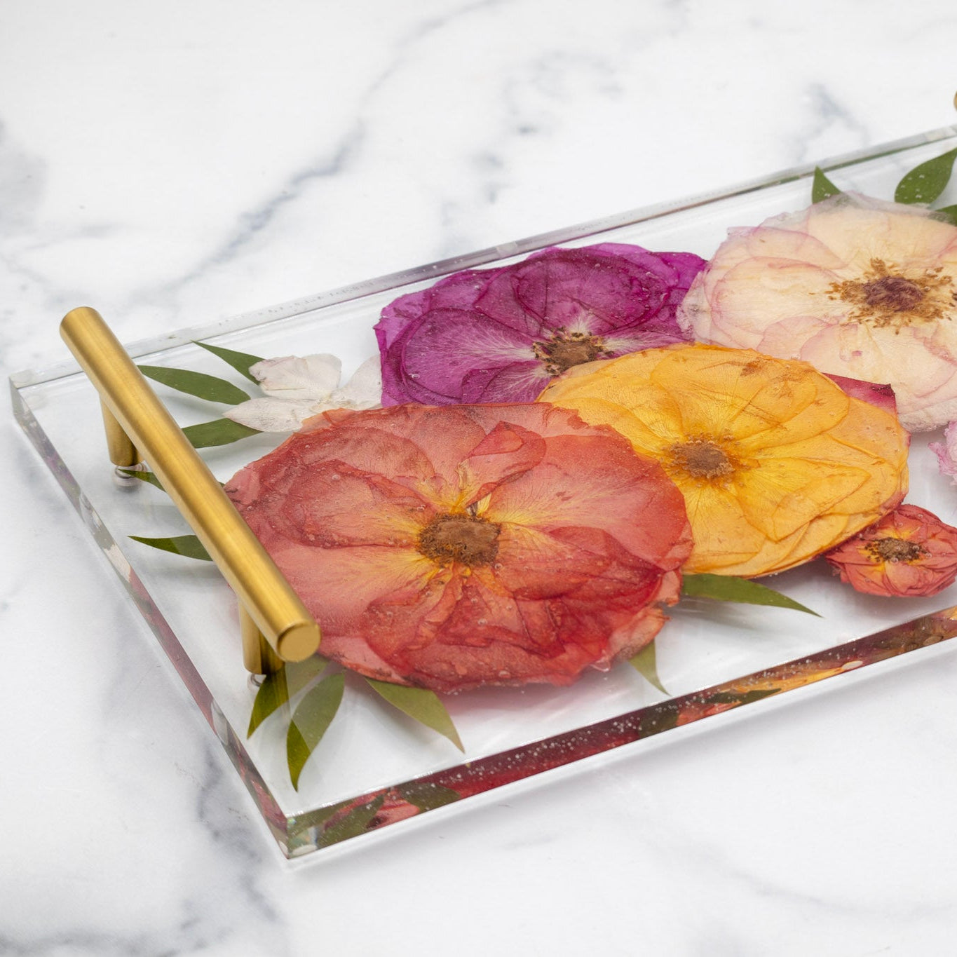 Decorative resin tray with pressed floral design on a marble surface