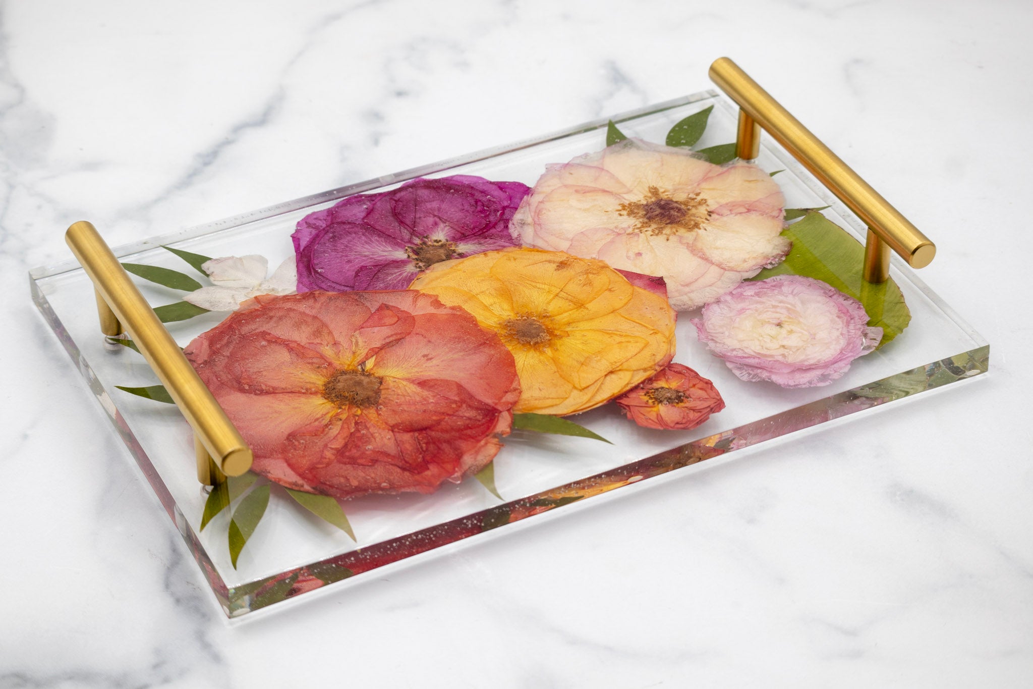 Decorative resin tray with pressed floral design on a marble surface