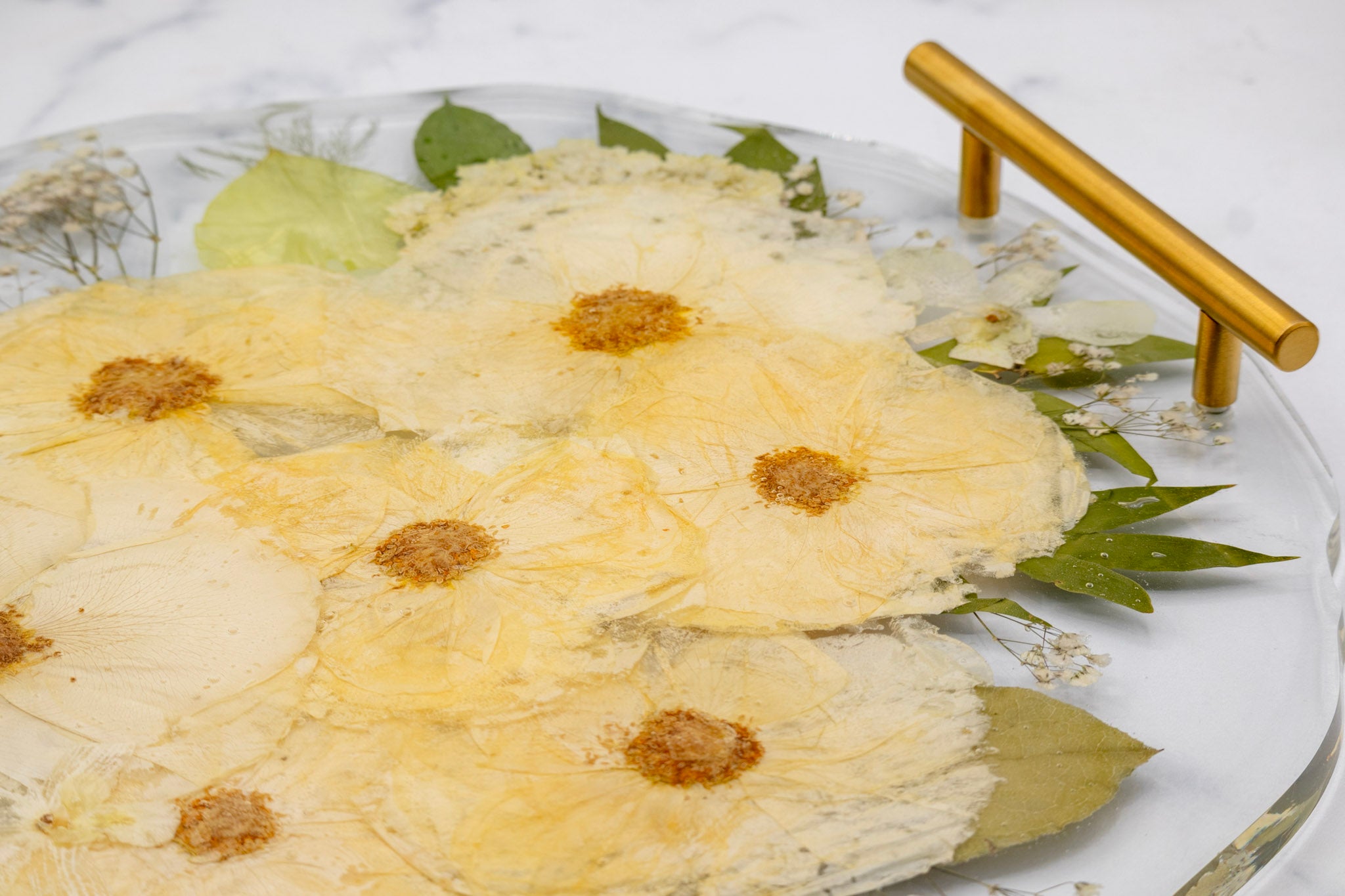 Dried pressed rose flowers preserved in a resin plate with a gold handle