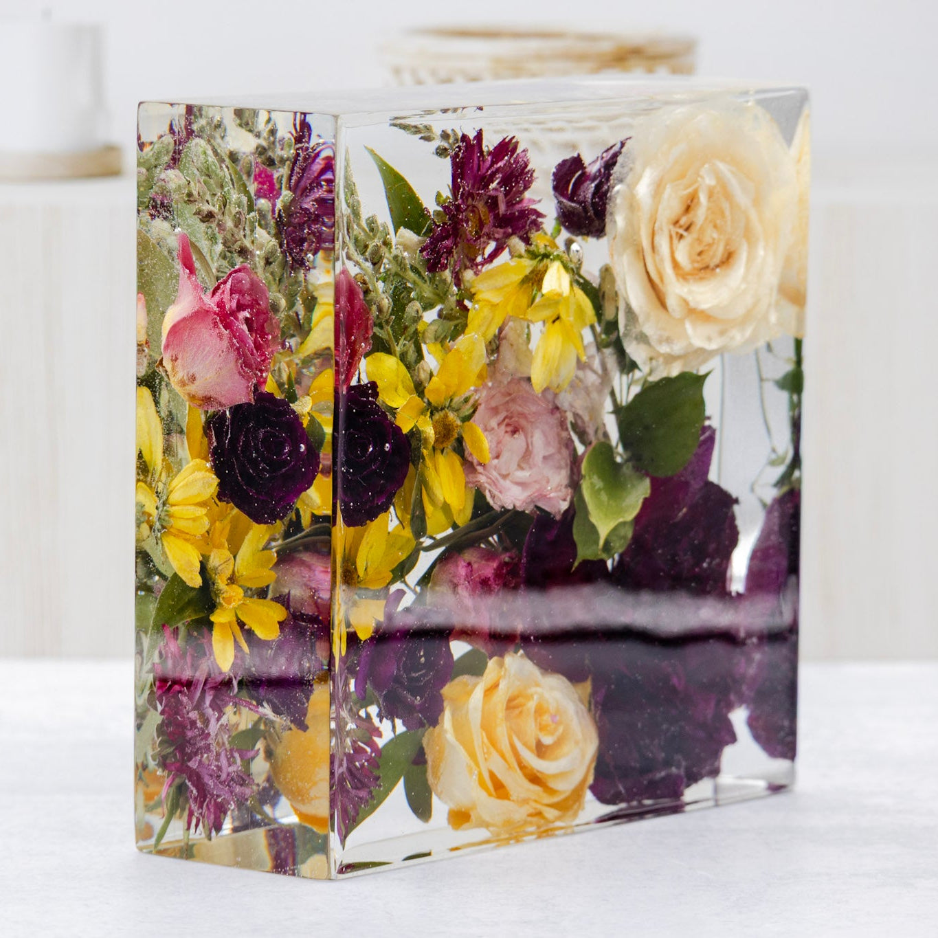 Resin block with preserved flowers on a white surface