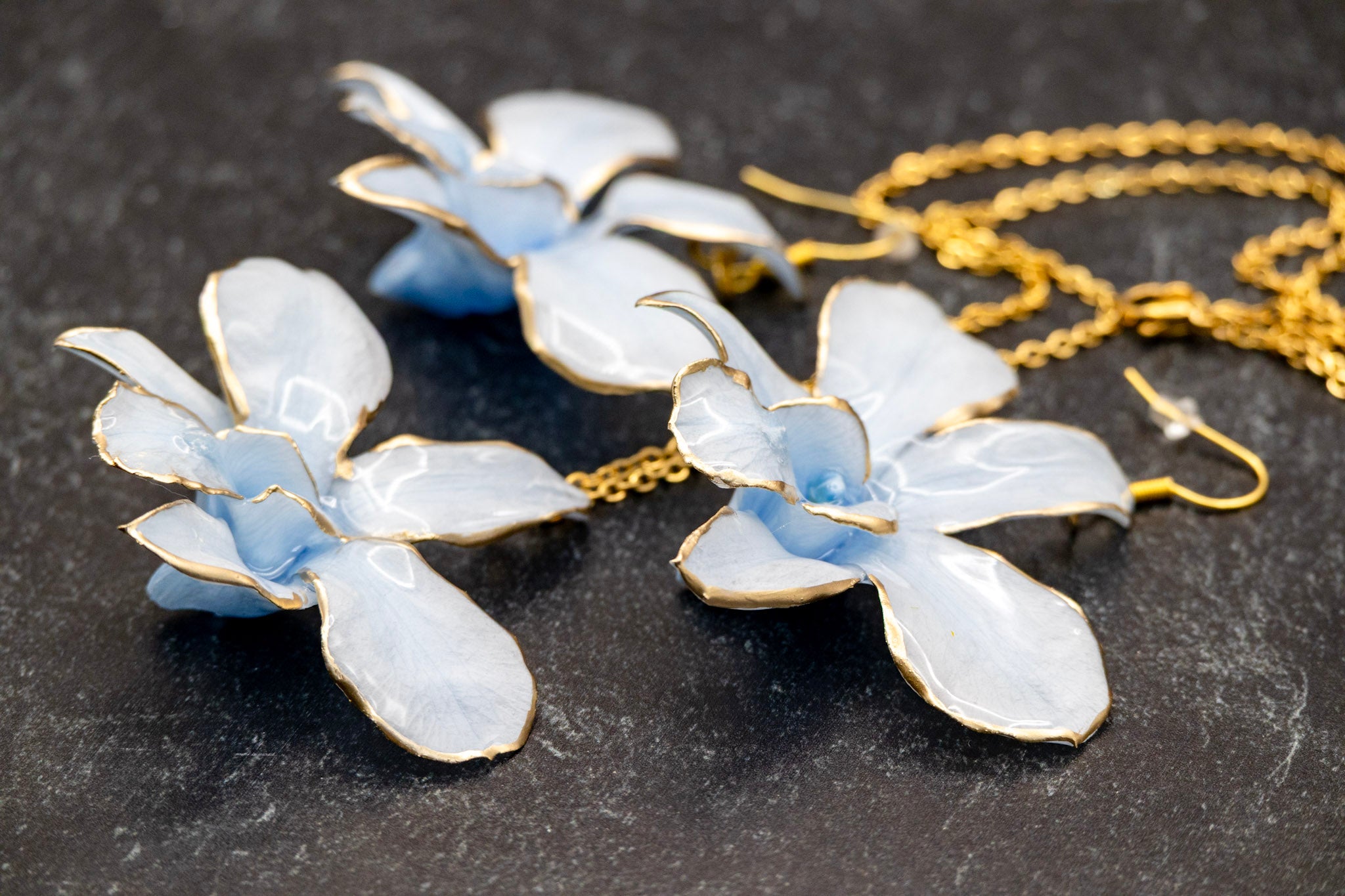 Floral jewelry set with blue and white flowers on a dark background orchid jewelry