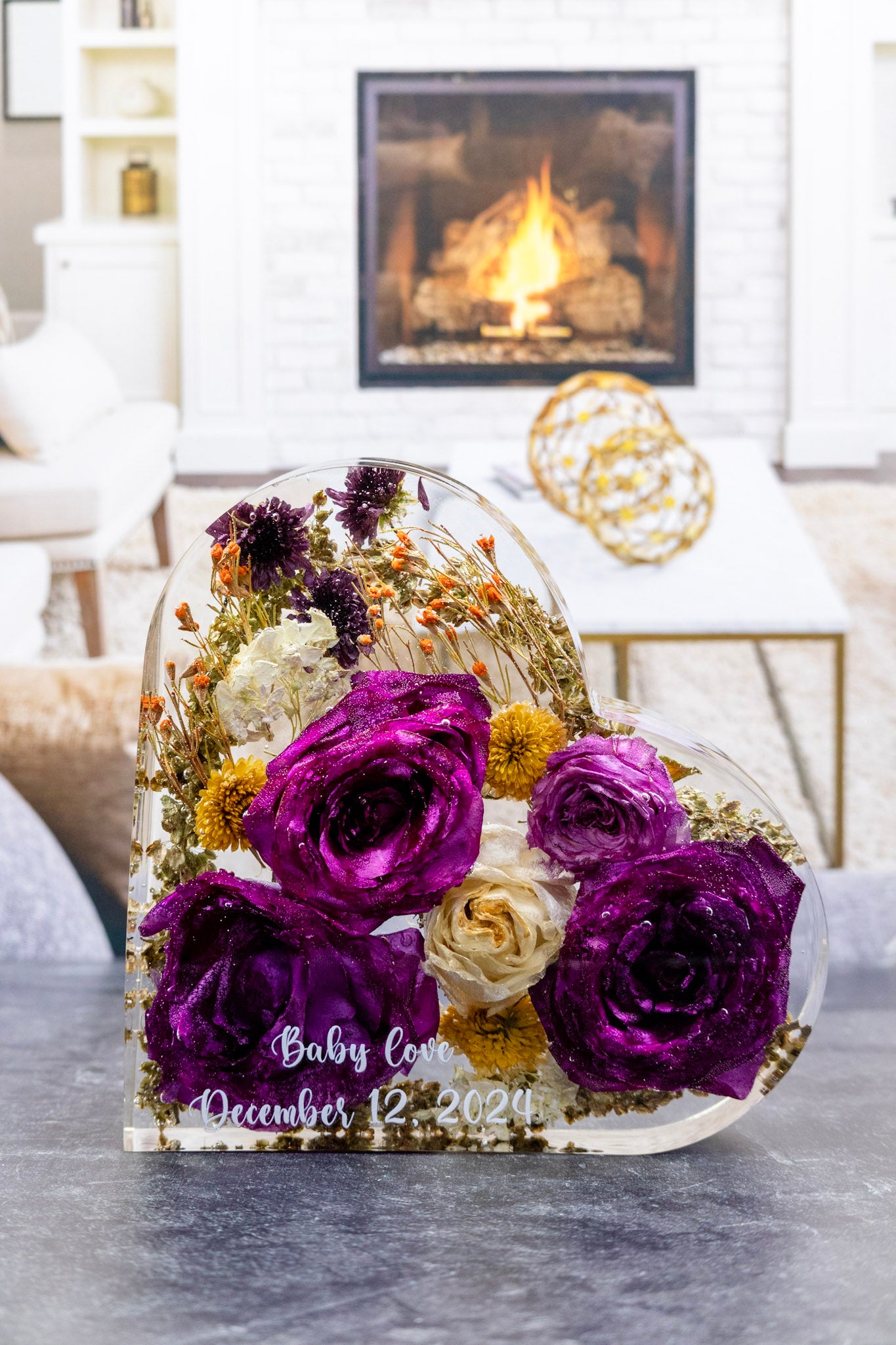 Decorative glass dome with purple and white flowers on a table in a cozy living room.