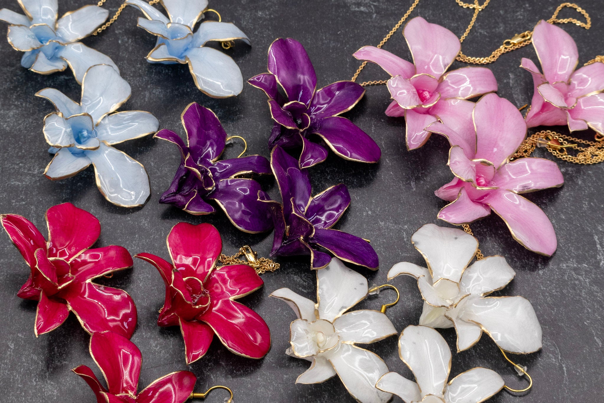 Colorful flower-shaped earrings on a dark surface