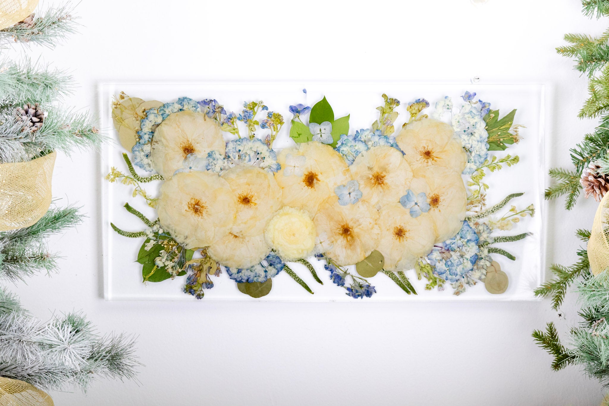 Decorative resin floral preservation with white roses and green leaves on a wall