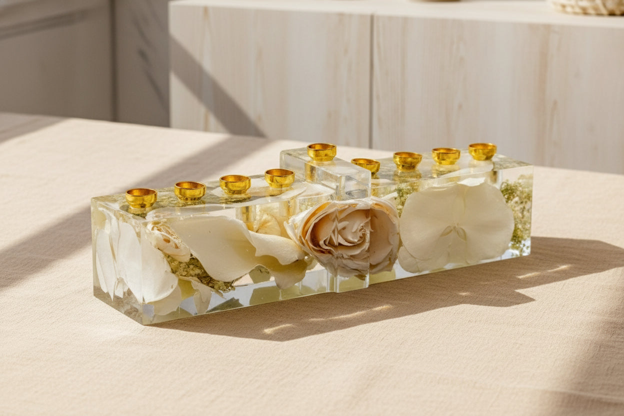 Jewish wedding flower preservation menorah with gold candle cups and color corrected white flowers on a gray surface.