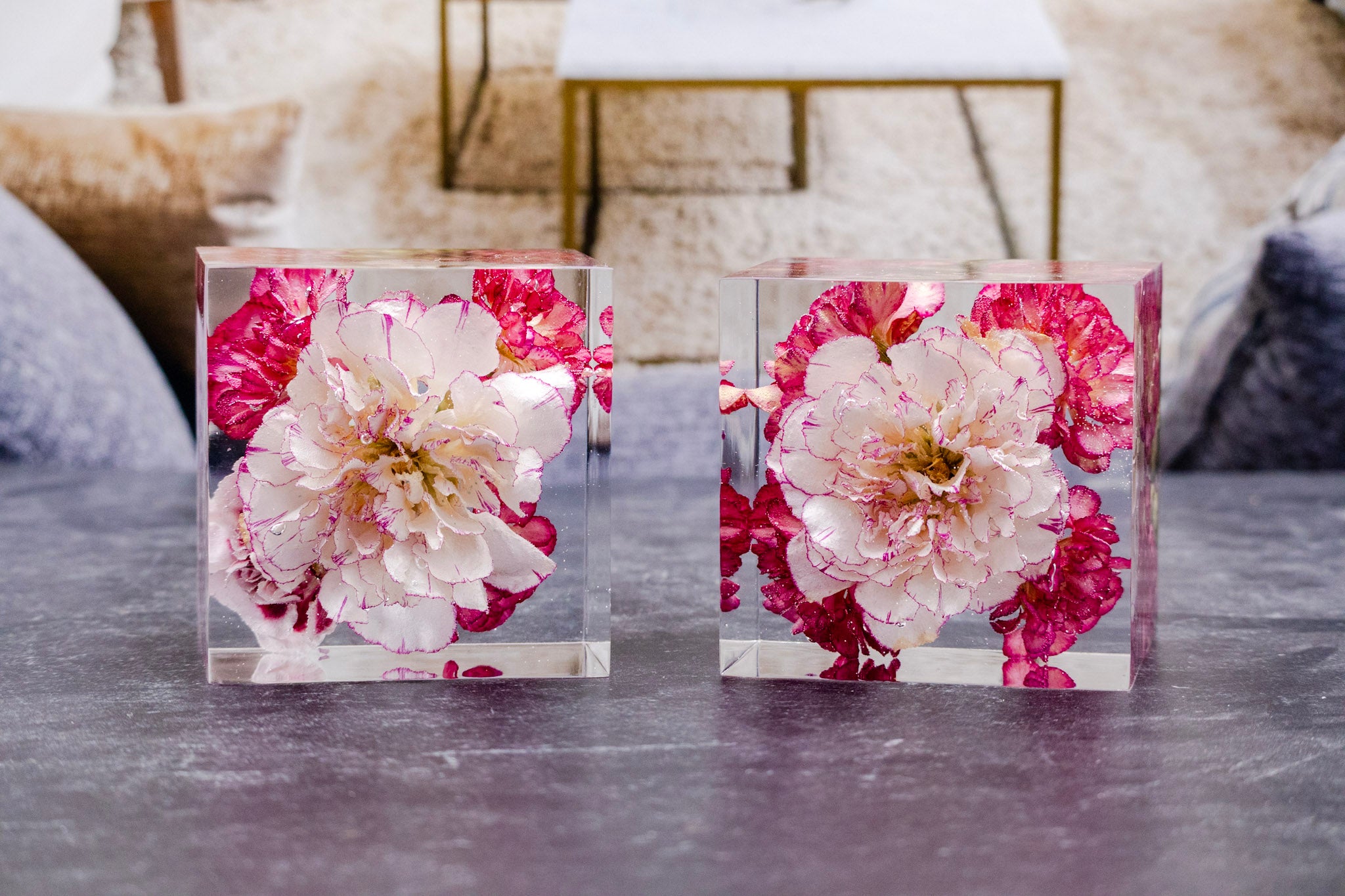 prom flower preservation Two clear acrylic blocks with pink and white flowers on a marble surface.