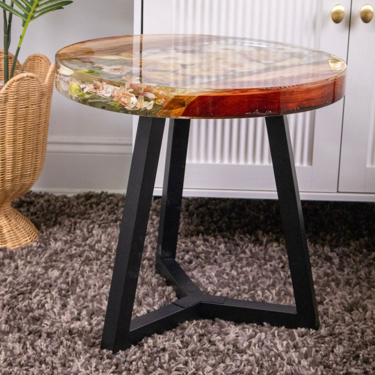 Side view of resin wood pedestal table with black metal legs