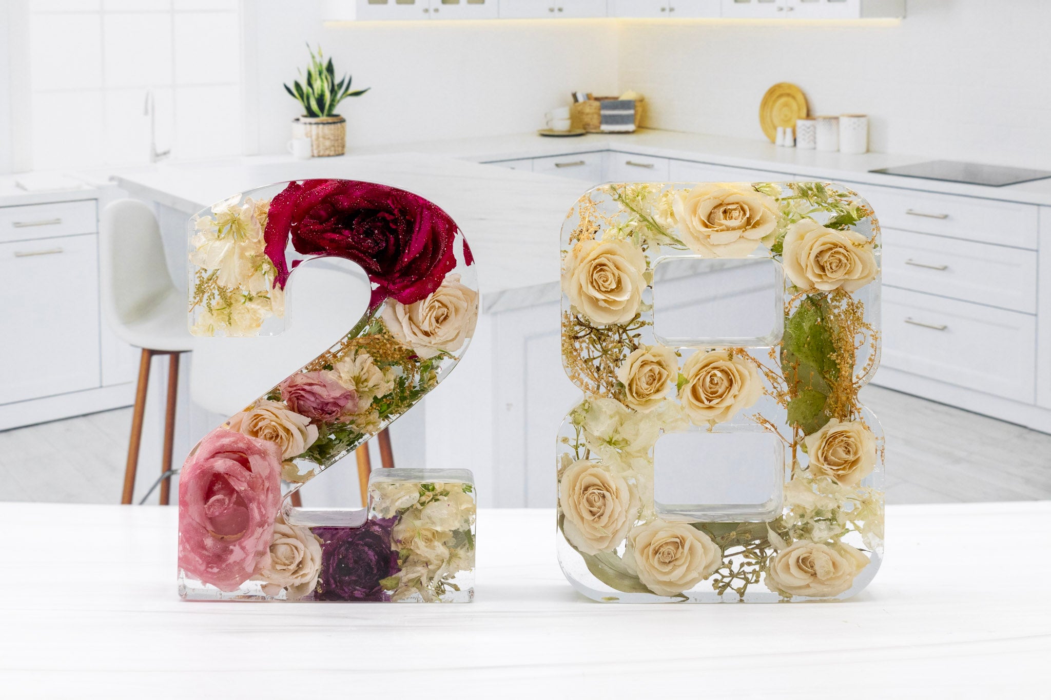 Decorative numbers '28' made of two different wedding bouquet flowers on a kitchen counter.