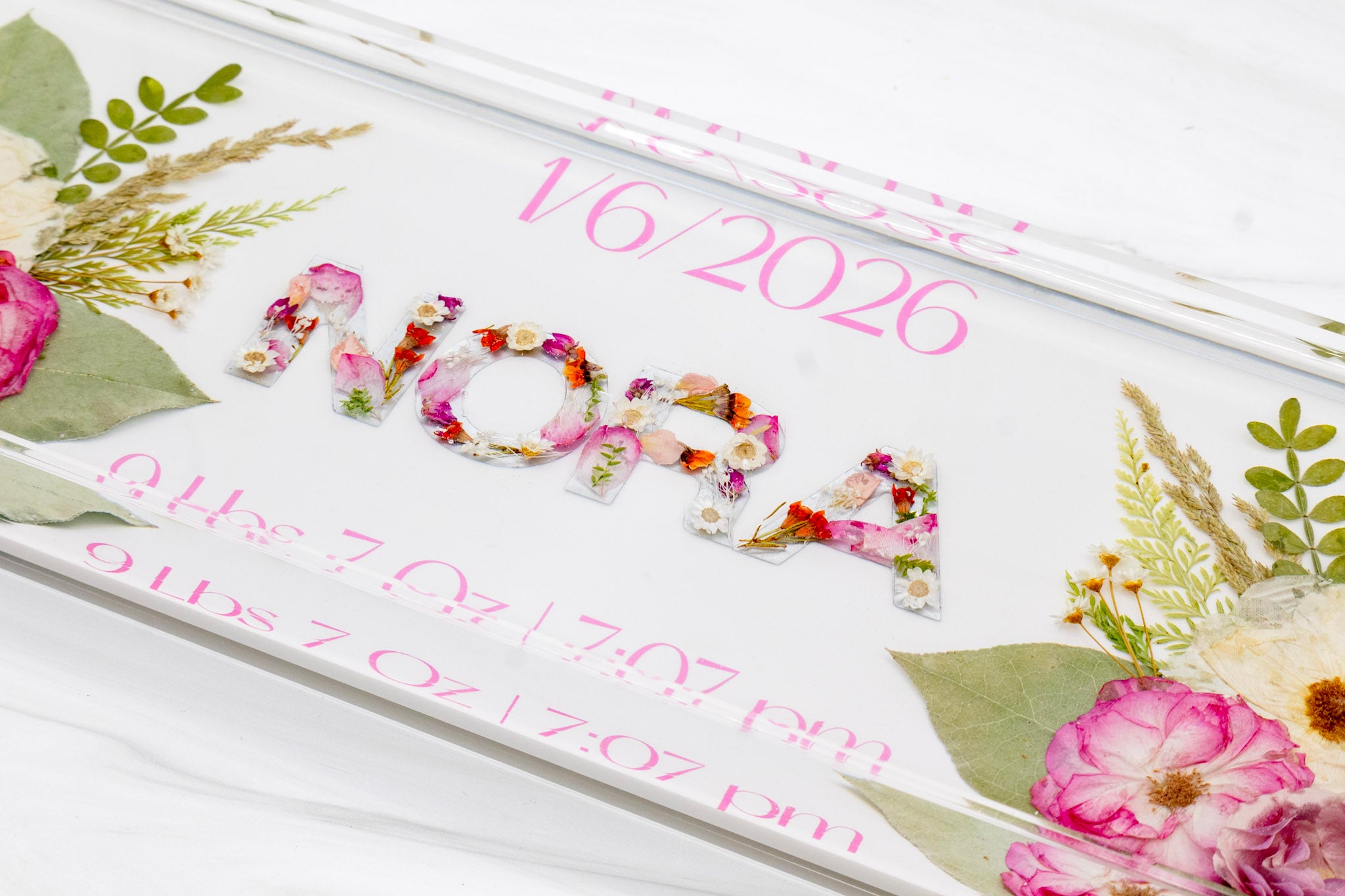 Baby milestone board with floral design and text on a white background