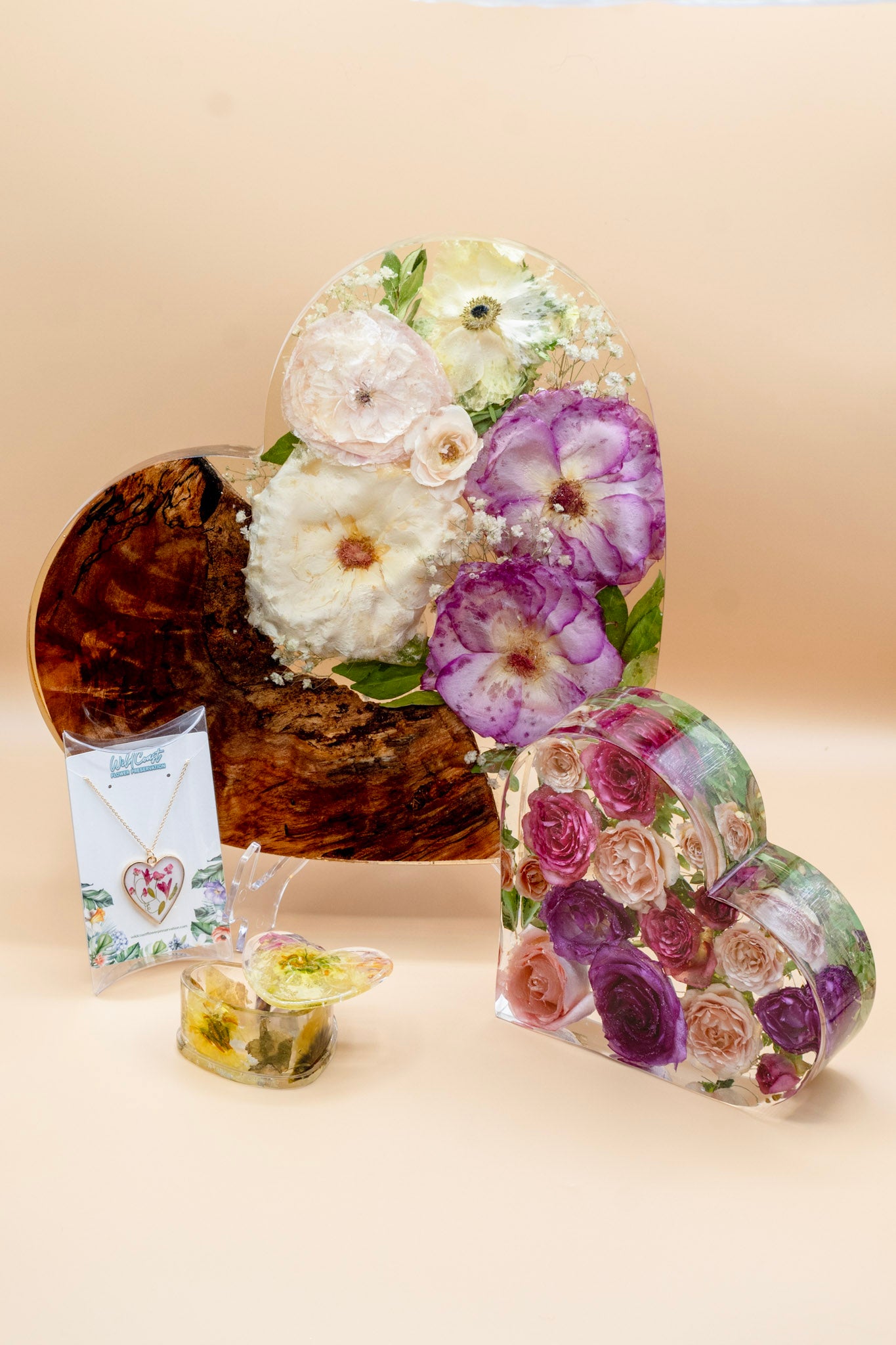 Wedding Bouquet preservation heart-shape collection contains resin heart necklace with preserved petals, resin heart-shape jewelry box with pressed petals, 6" resin hear block standing display and 13" resin wood charcuterie board