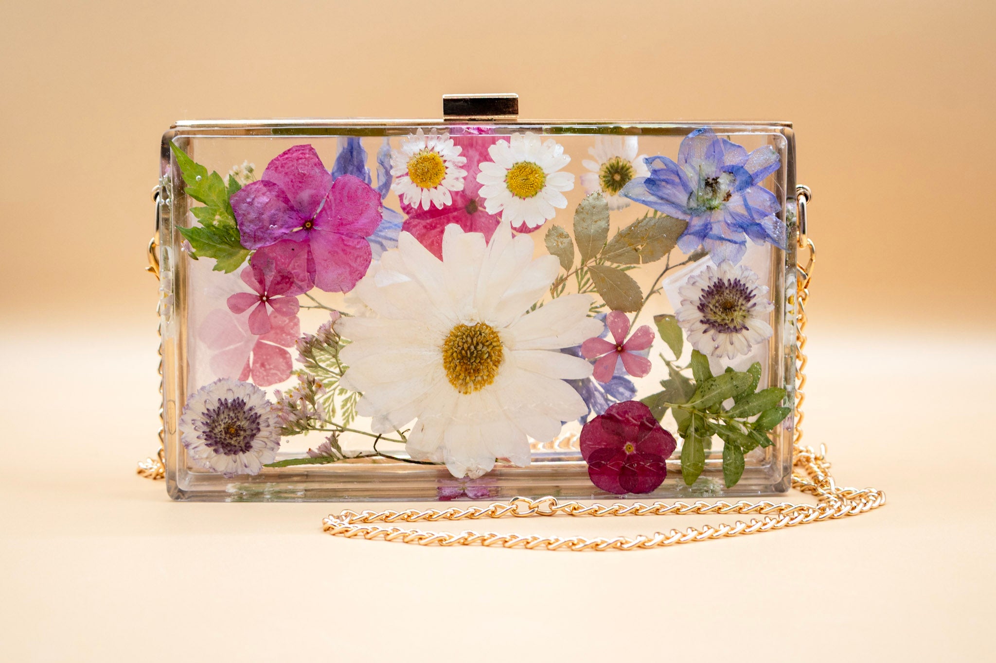 Clutch bag with pressed flowers on a beige background