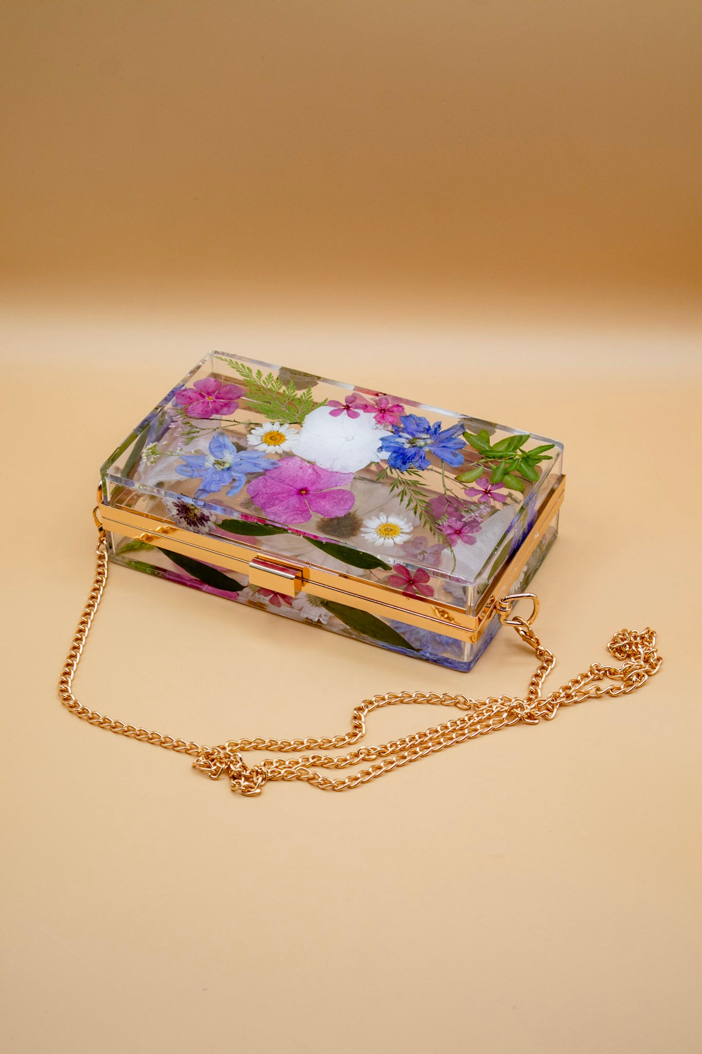 Real Flower handbag with a gold chain on a beige background