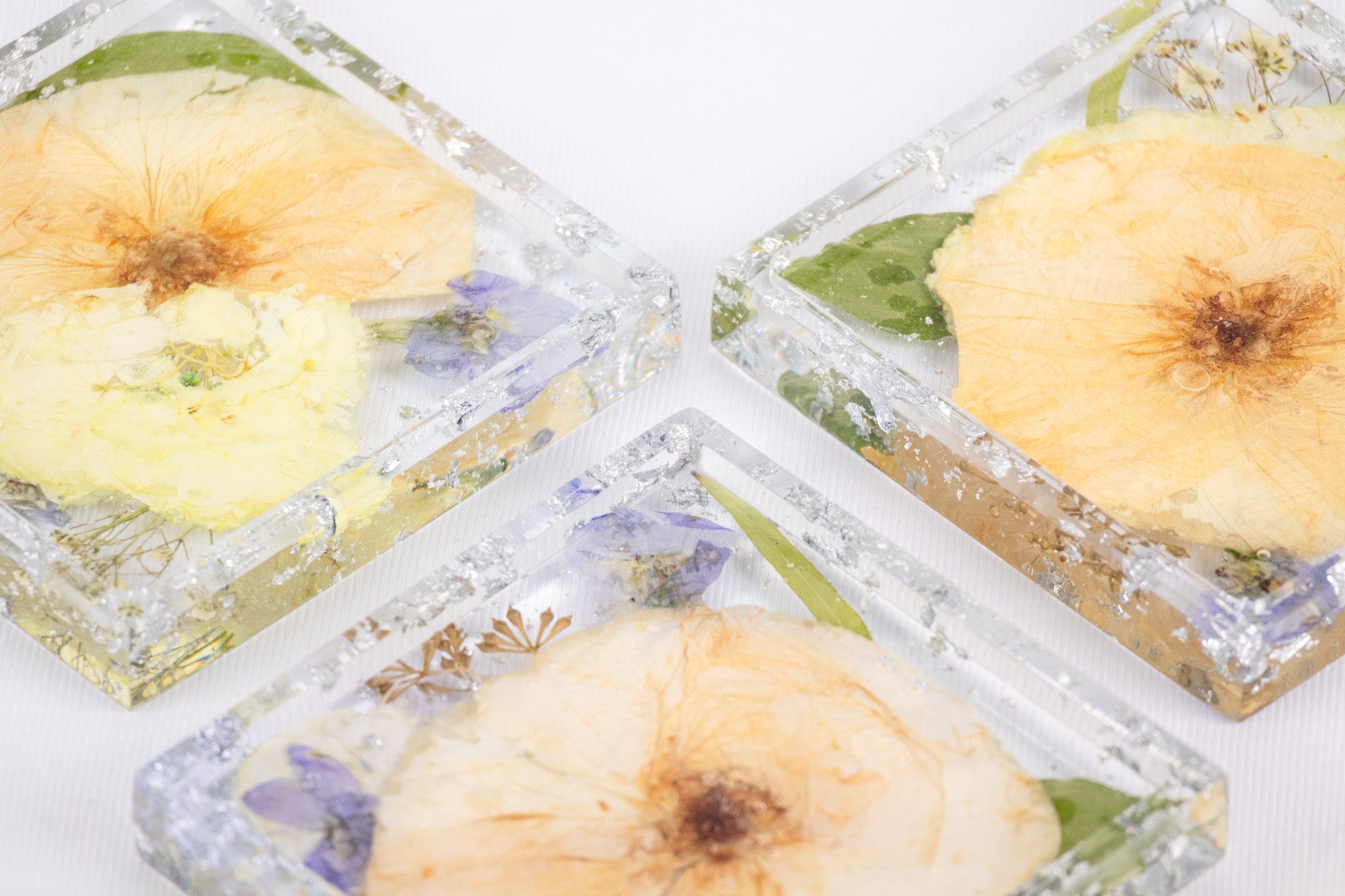 close up shot of our square pressed flower trinket trays with silver flake accents.