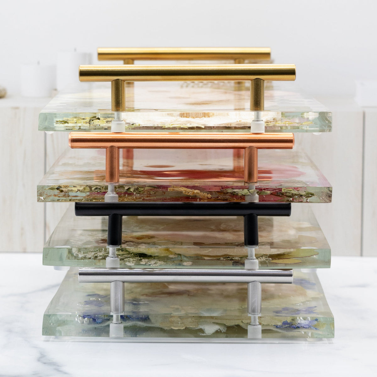 Stack of trays with handles in various finishes on a white background with text about hardware finishes.